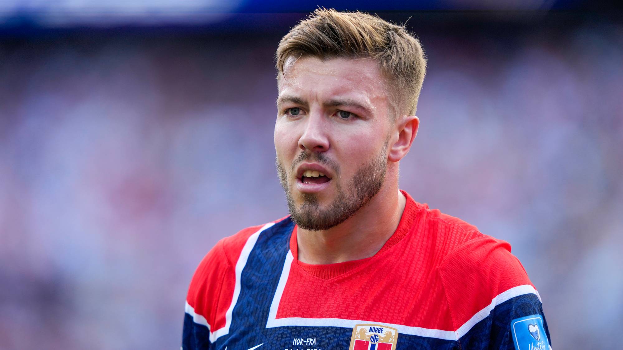 Fotballspilleren Alexander Sørloth i den norske landslagsdrakten på en fotballbane. (Bildebeskrivelsen er laget av en KI-tjeneste)