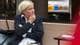 Vetle Hjortland / NRK En kvinne med blondt hår, hvit skjorte, blå blazer og beige bukser sitter ved et bord. Hun ser tankefull ut.