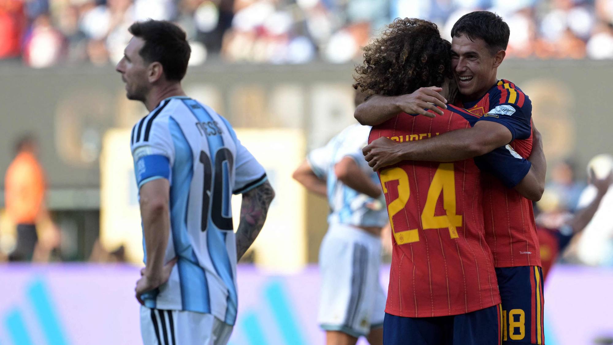 Spanske spillere feirer en scoring mens Lionel Messi ser bort på en fotballbane. (Bildebeskrivelsen er laget av en KI-tjeneste)