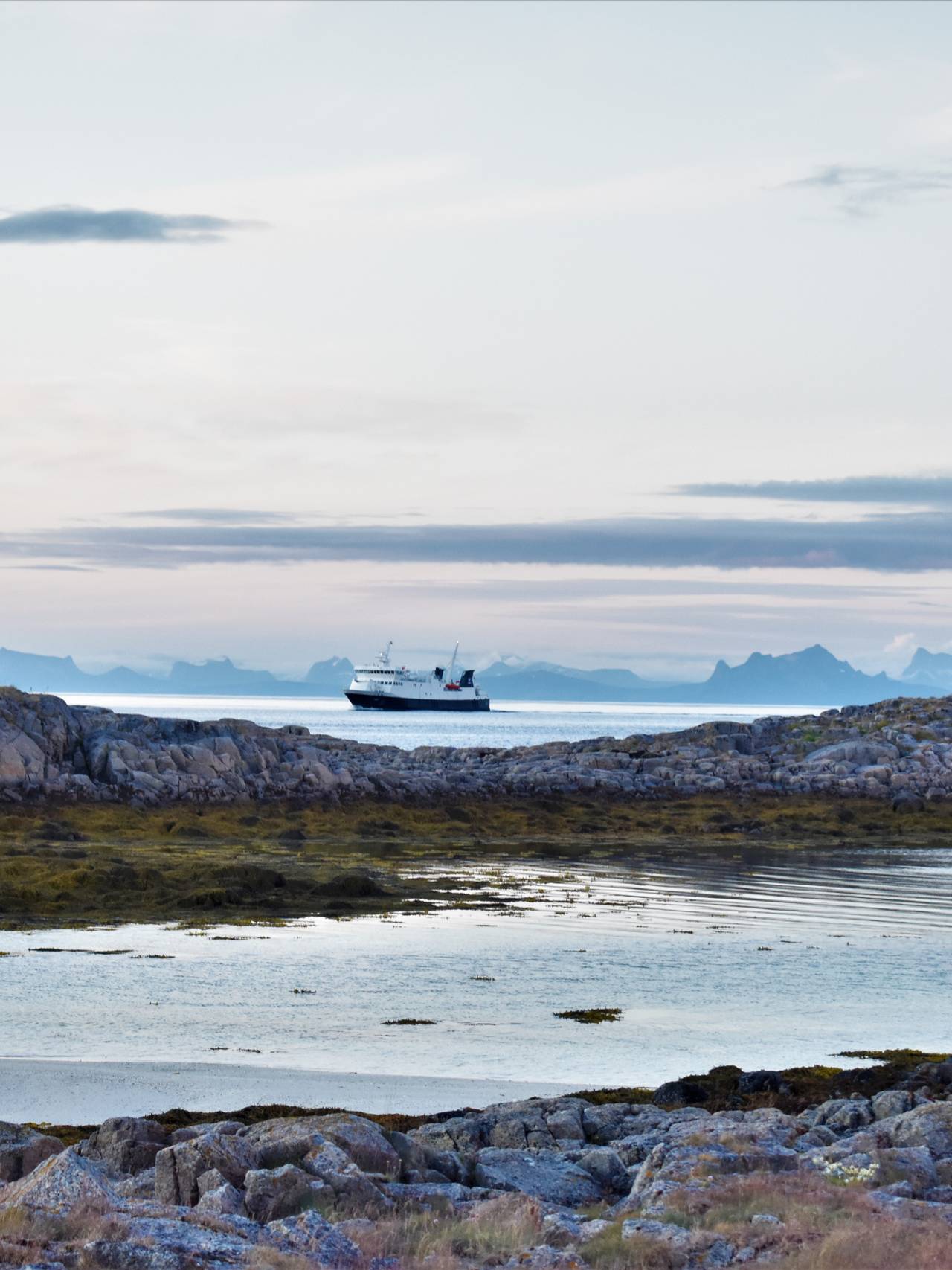 Ferge kjører med Lofoten i bakgrunn.