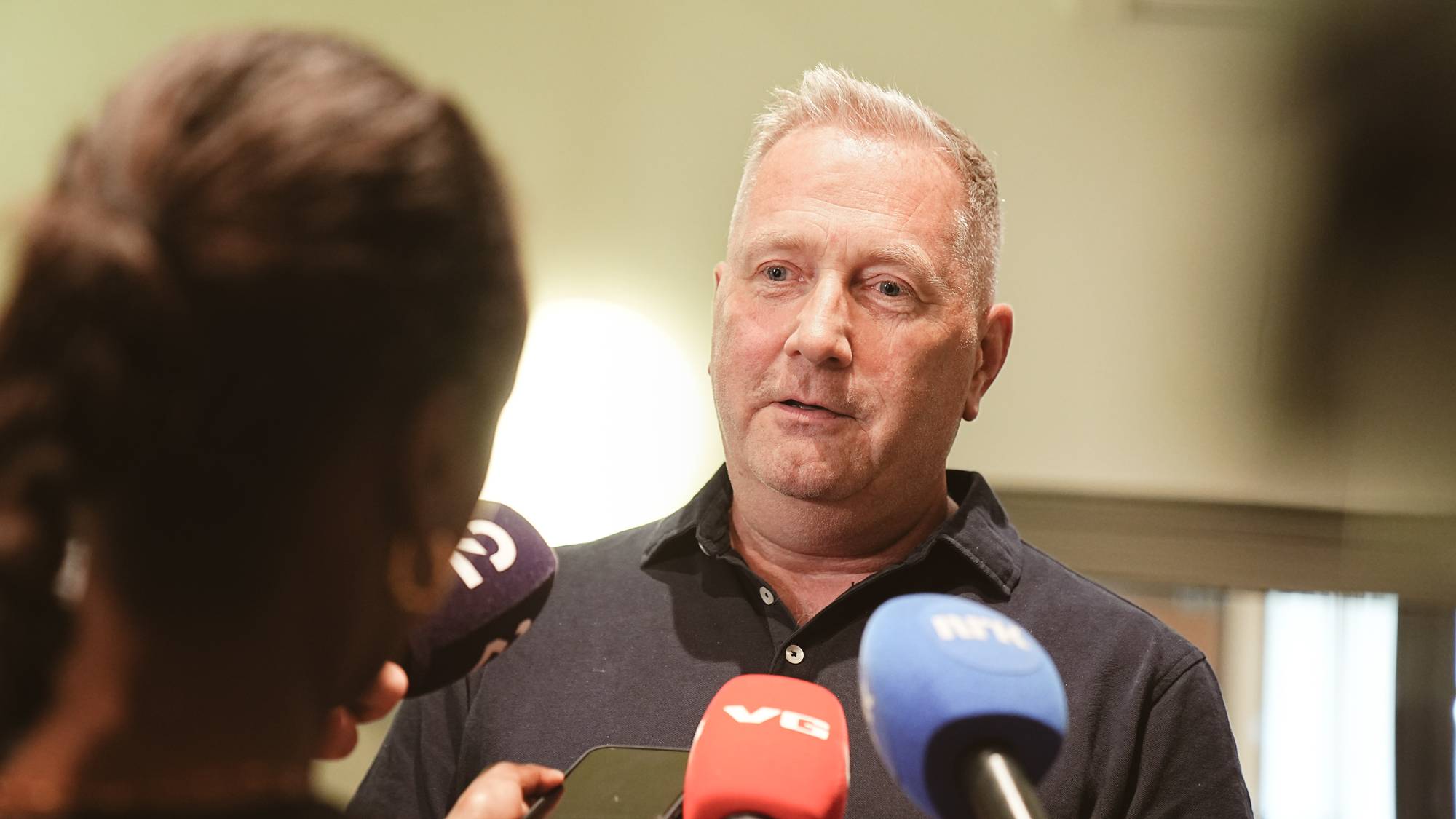 Portrett av en middelaldrende mann med grått hår som står foran pressen, eder i SAS sin kabinforening, Parat, Martin Røkkum
