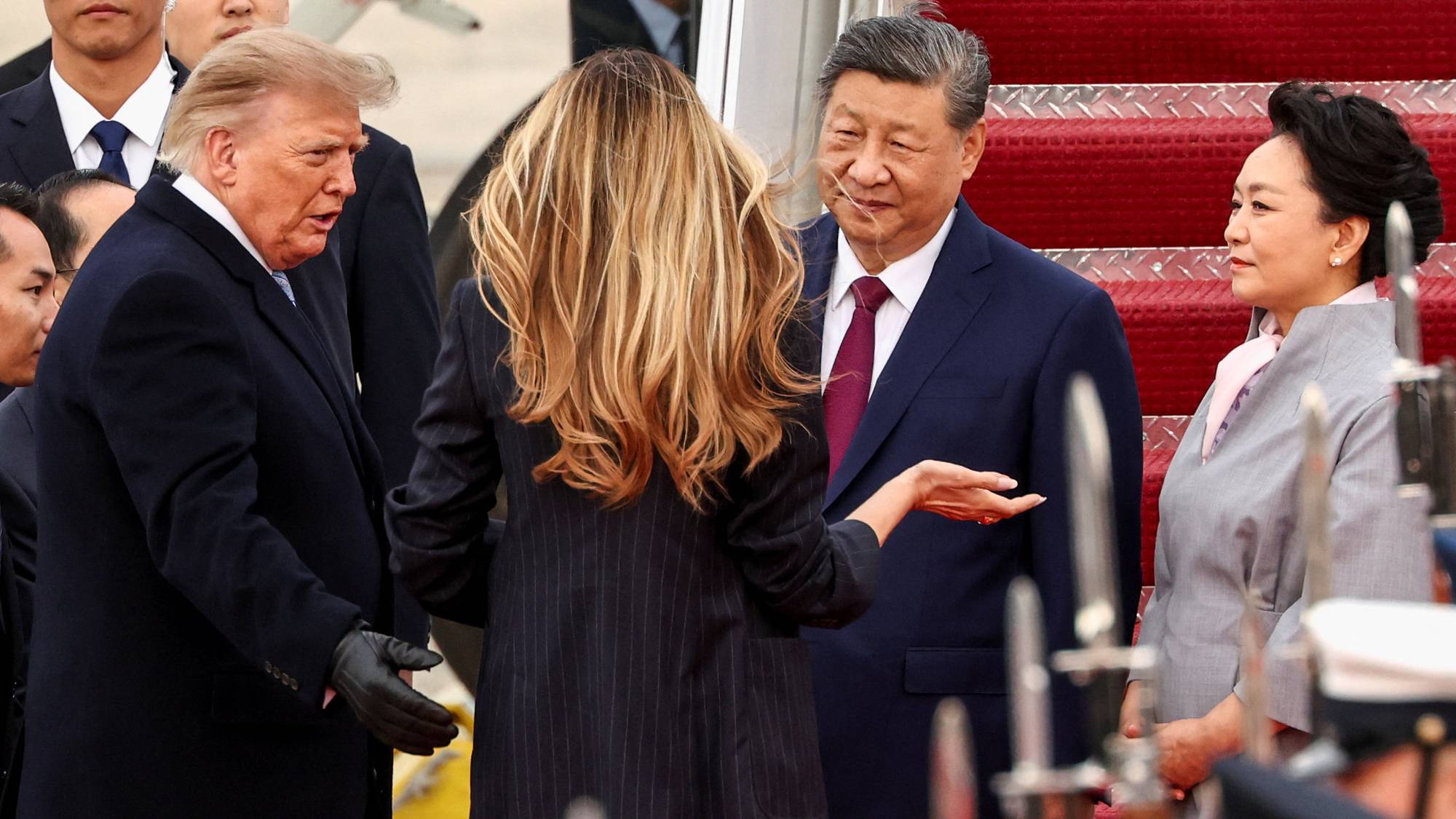 Donald og Melania Trump i samtale med Xi Jinping og Xi ektefelle Peng Liyuan nederst ved flytrappen. 