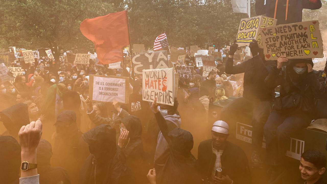 Rød tifo-røyk under demonstrasjonen utenfor den amerikanske ambassaden.