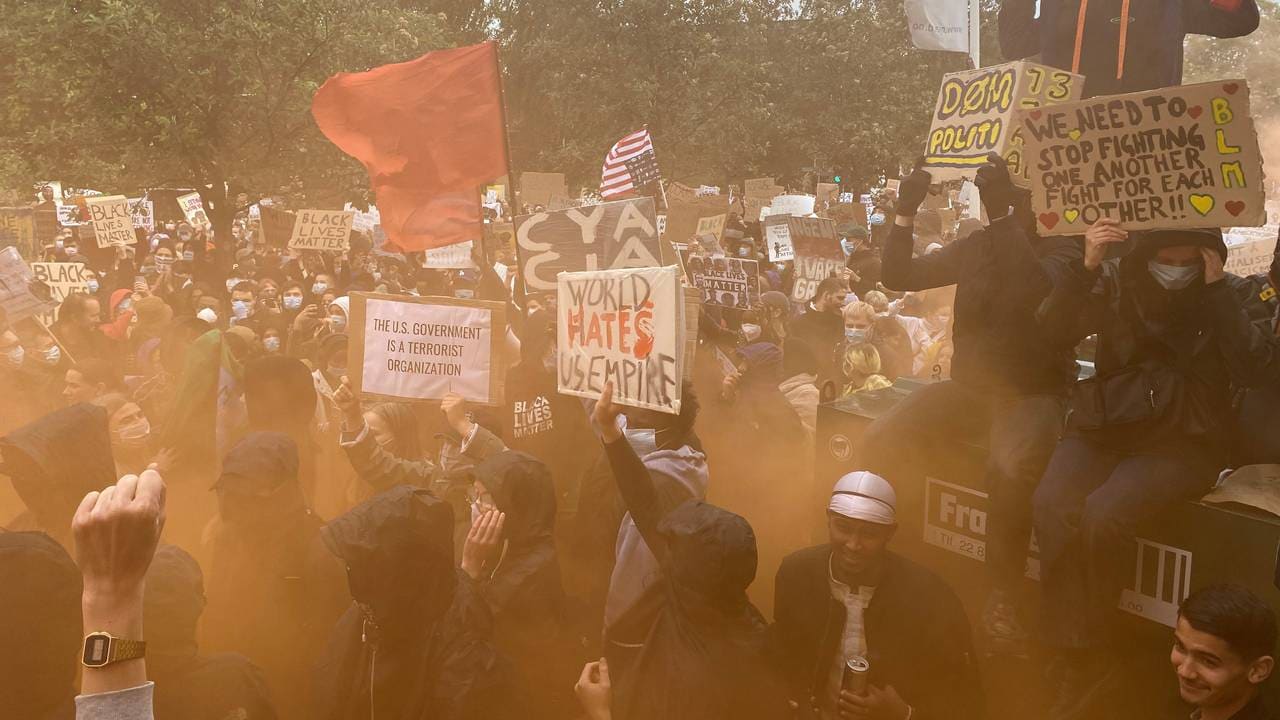 Rød tifo-røyk under demonstrasjonen utenfor den amerikanske ambassaden.