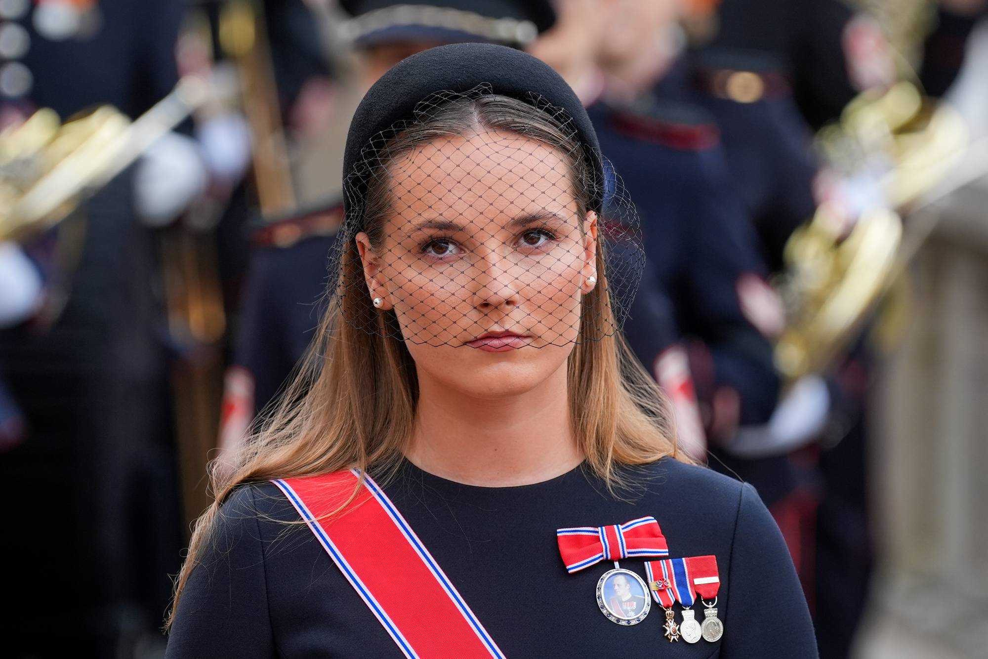 Kronprinsesse Ingrid Alexandra med sort kjole og en sort hårbøyle med sørgeslør foran ansiktet