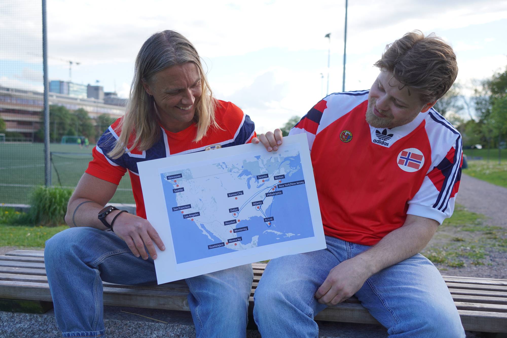 To menn i landslagstrøyer til Norge med kart over USA med streker som viser flyreiser