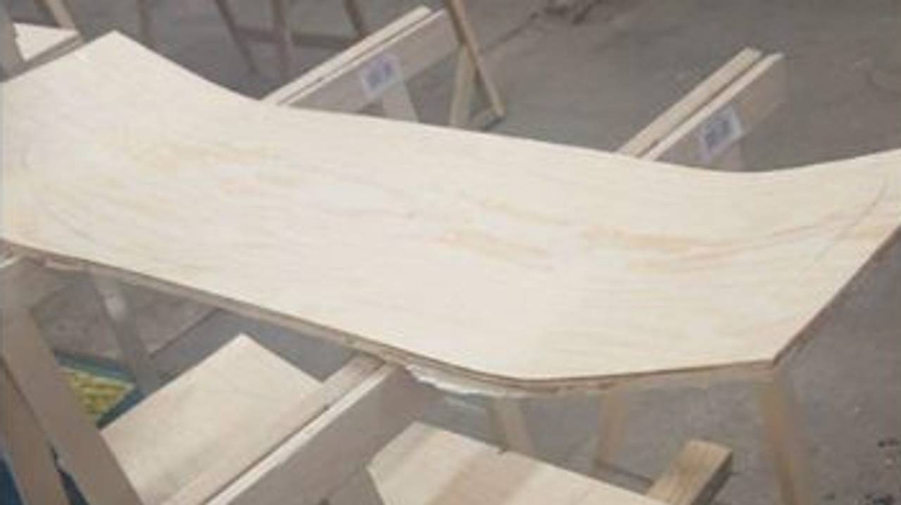 Sammenlimte finérplater har fått buer og står til tørk før de blir skåret ut som skateboard