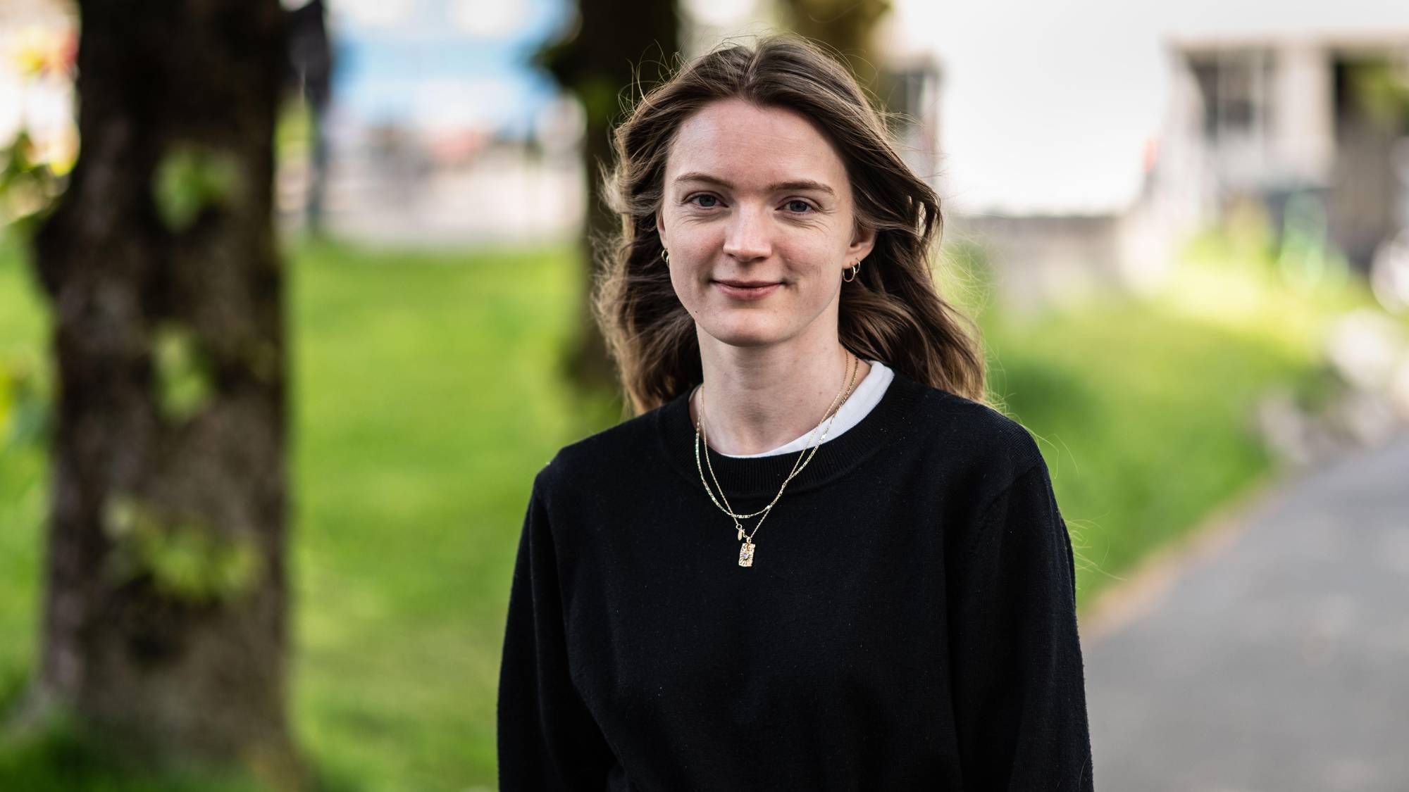 Emili Carin Rønning ser i kamera og smiler med lukket munn. 