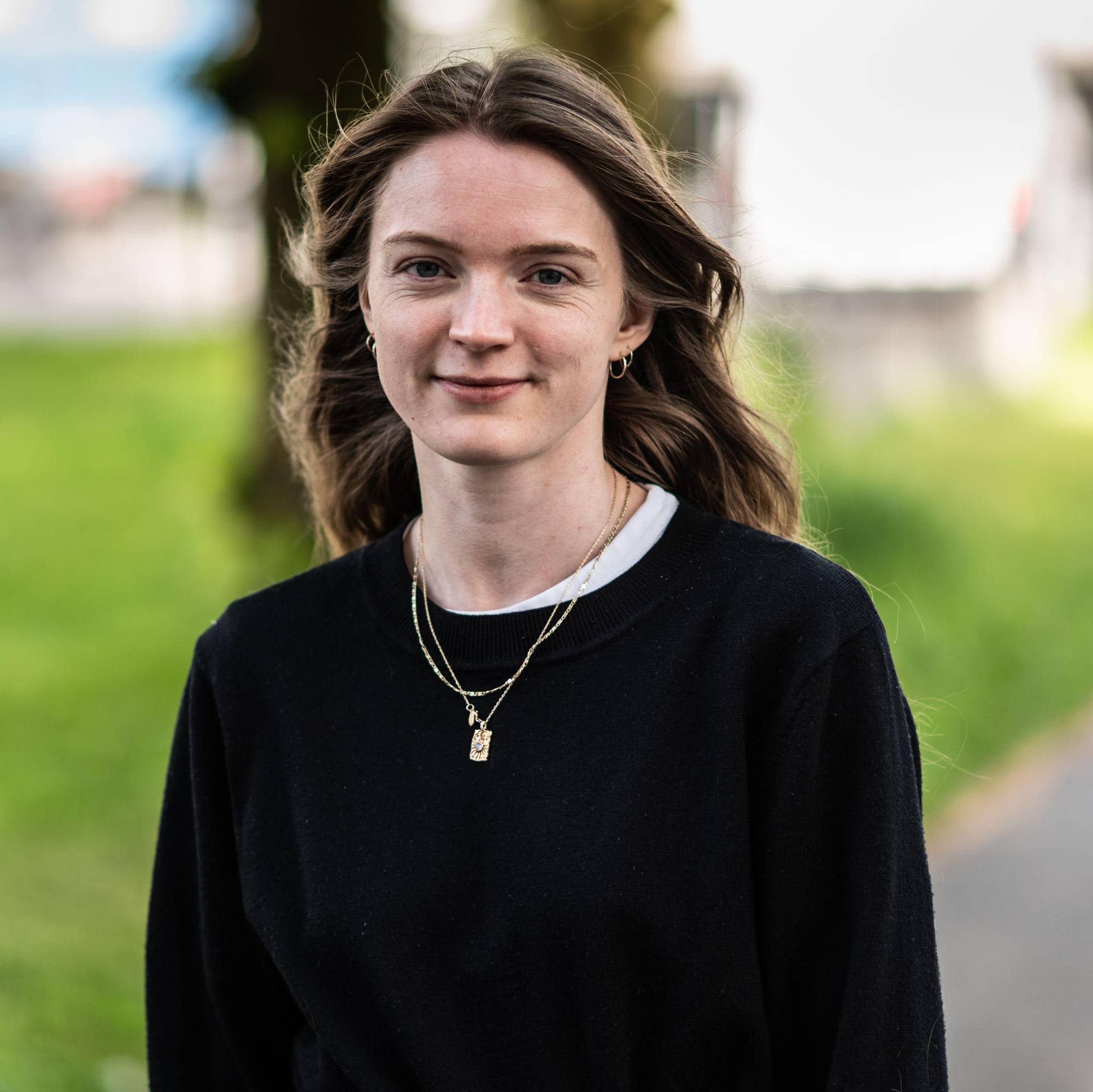 Emili Carin Rønning ser i kamera og smiler med lukket munn. 