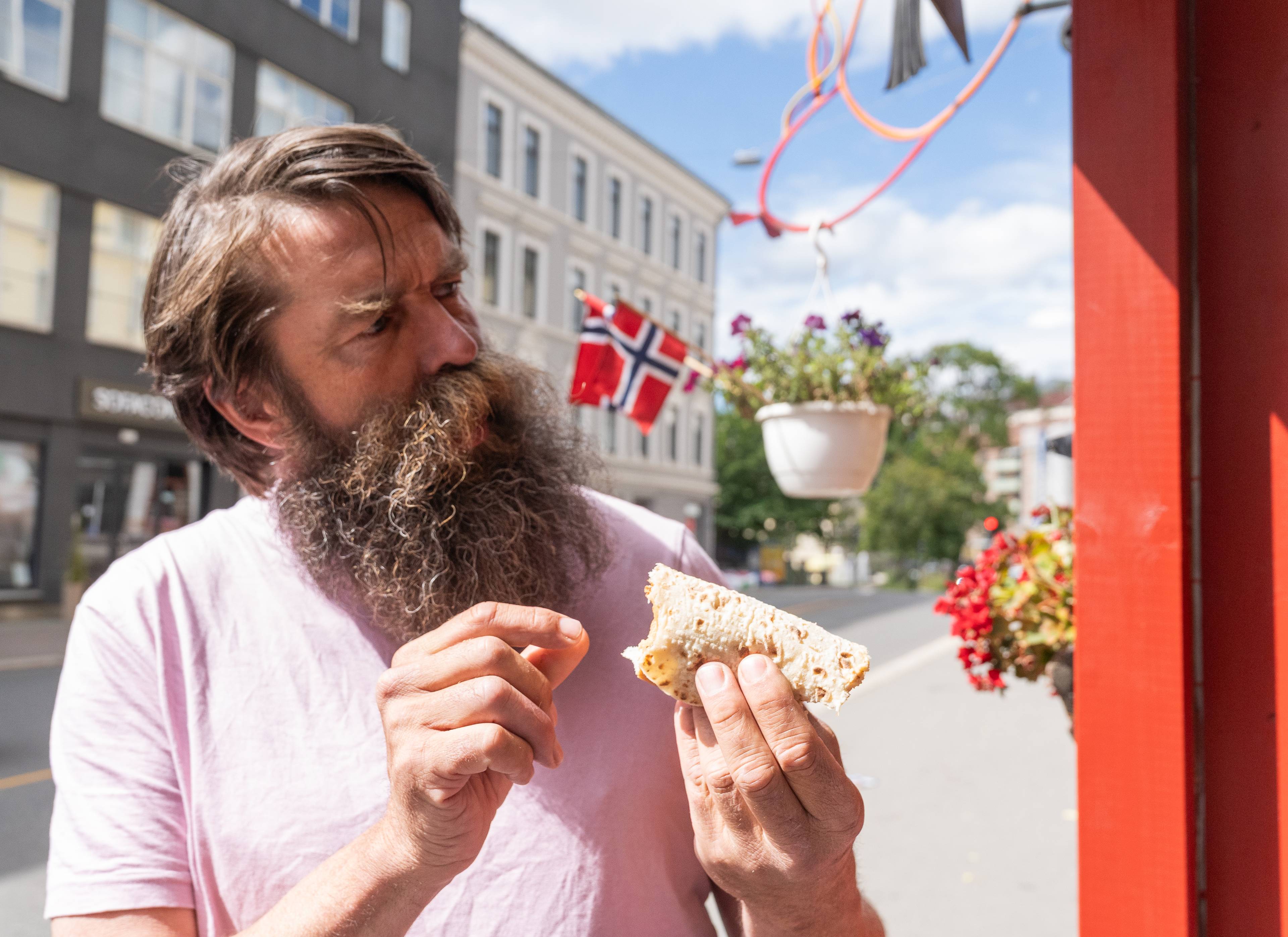 en person som spiser en pølse