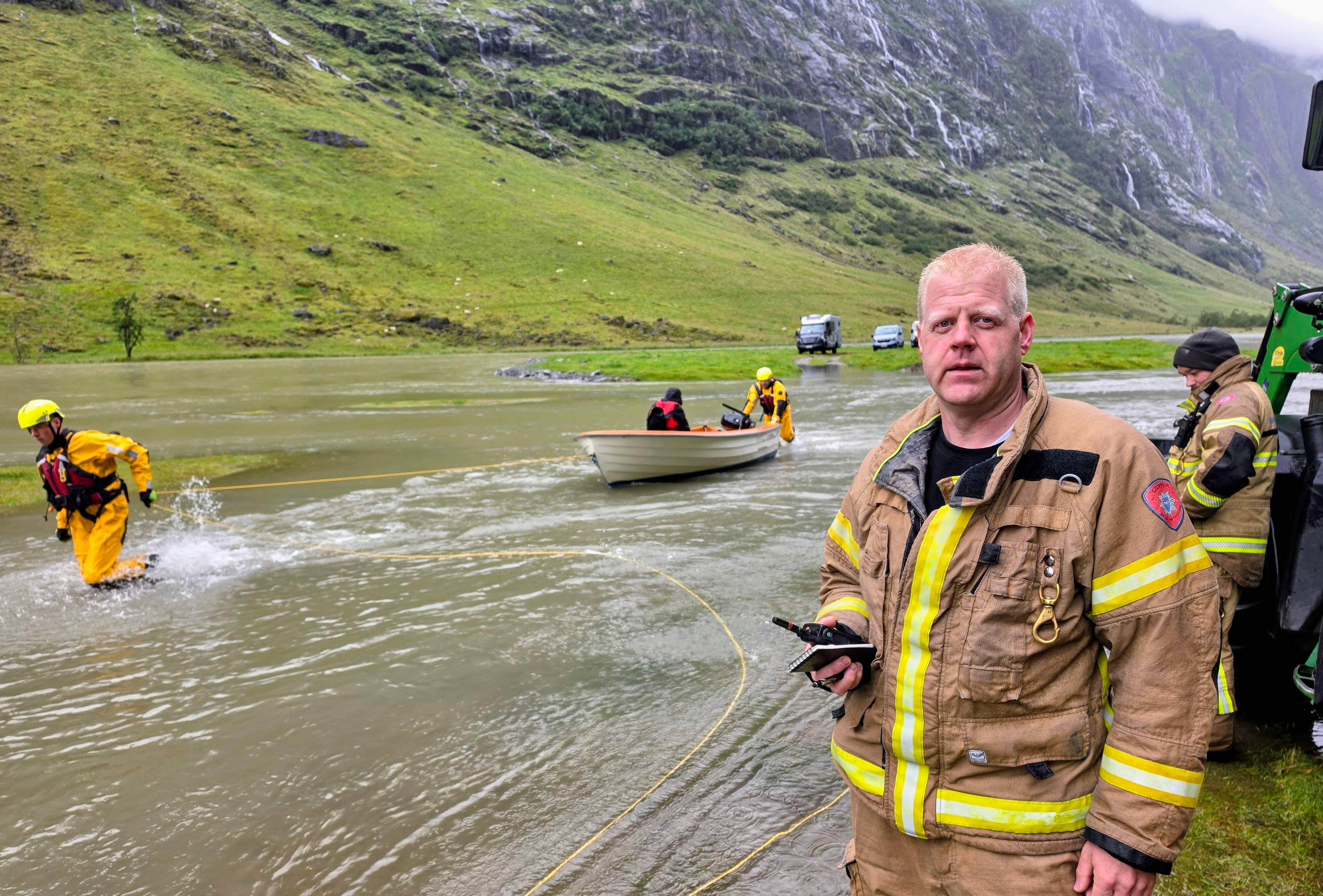 en brannmann som står ved en flomstor elv