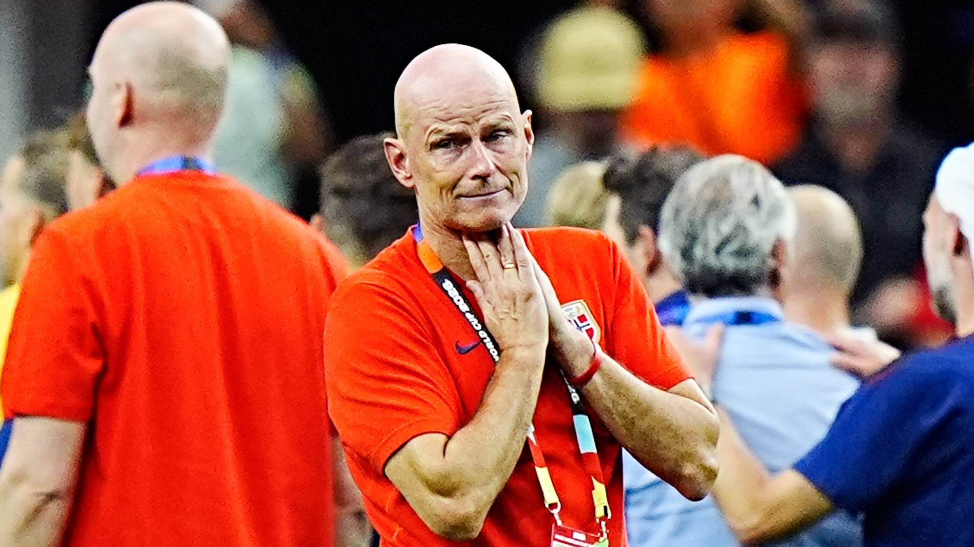 Landslagstrener Ståle Solbakken står på en fotballbane med hendene samlet under haken. (Bildebeskrivelsen er laget av en KI-tjeneste)
