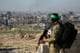 BASHAR TALEB / AFP / NTB En Hamas-kriger står på en bakketopp over Khan Younis.