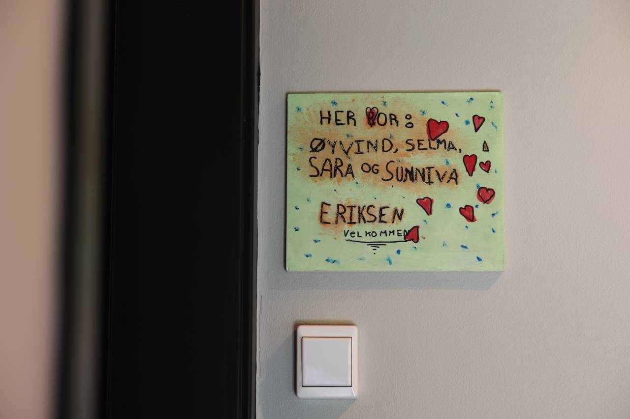 Et hjemmelaget dørskilt i grønt med hjerter på