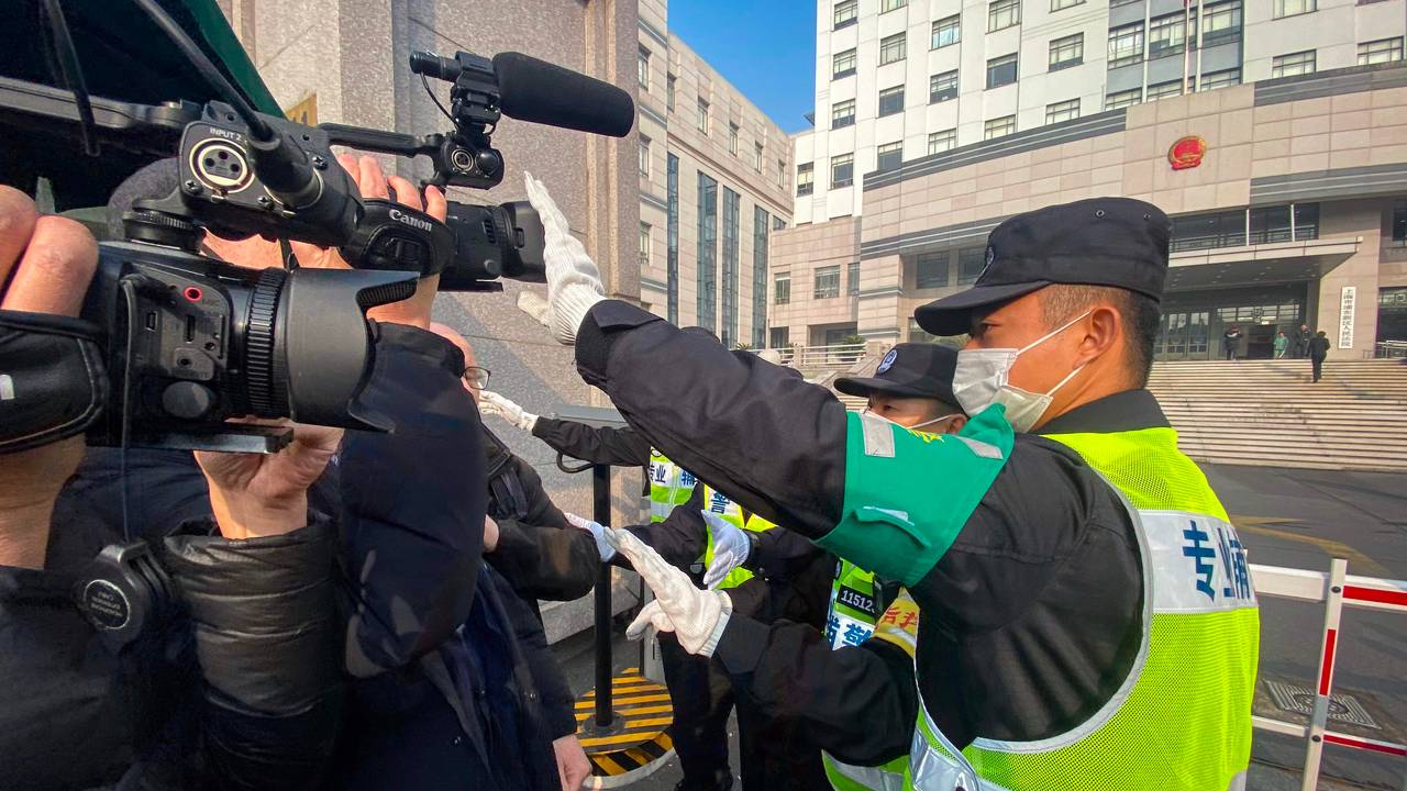 Chinese police prevent journalists from filming outside the courthouse where Zhang Zhan was sentenced to four years in prison on December 29. 