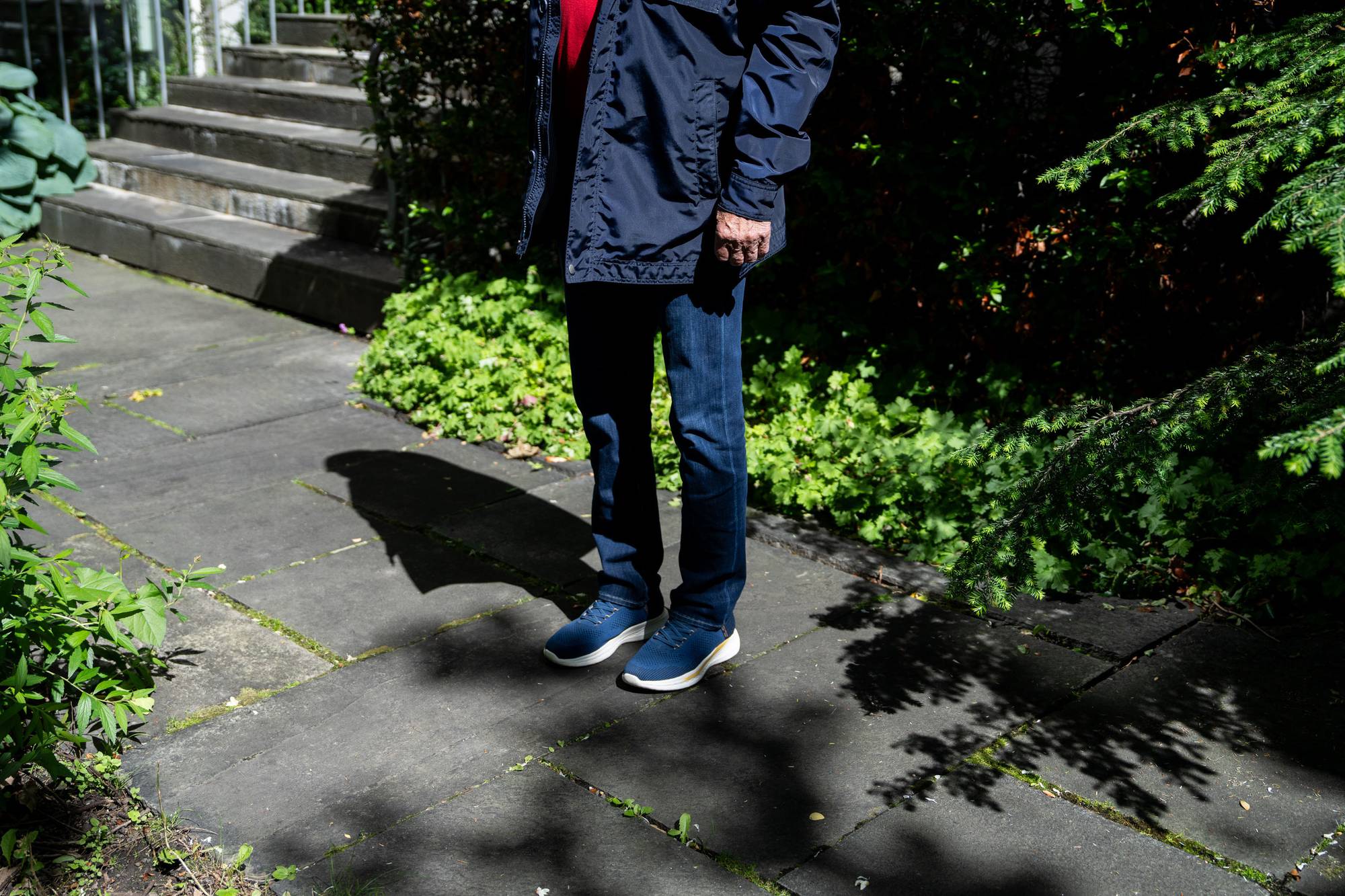 En person som står på en sti med planter og trapper.