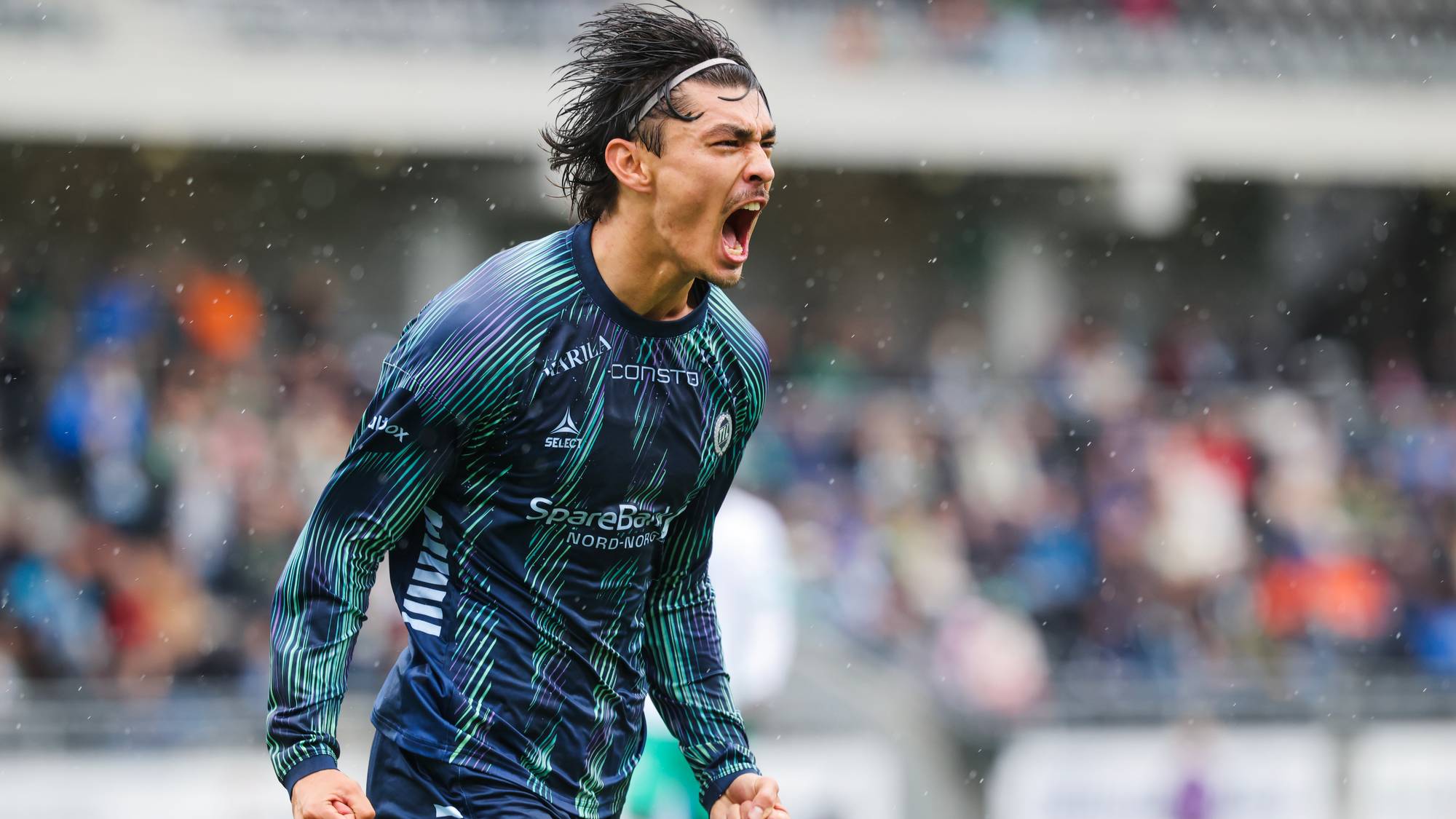 Fotballspiller jubler med knyttede never på en fotballbane foran publikum. (Bildebeskrivelsen er laget av en KI-tjeneste)