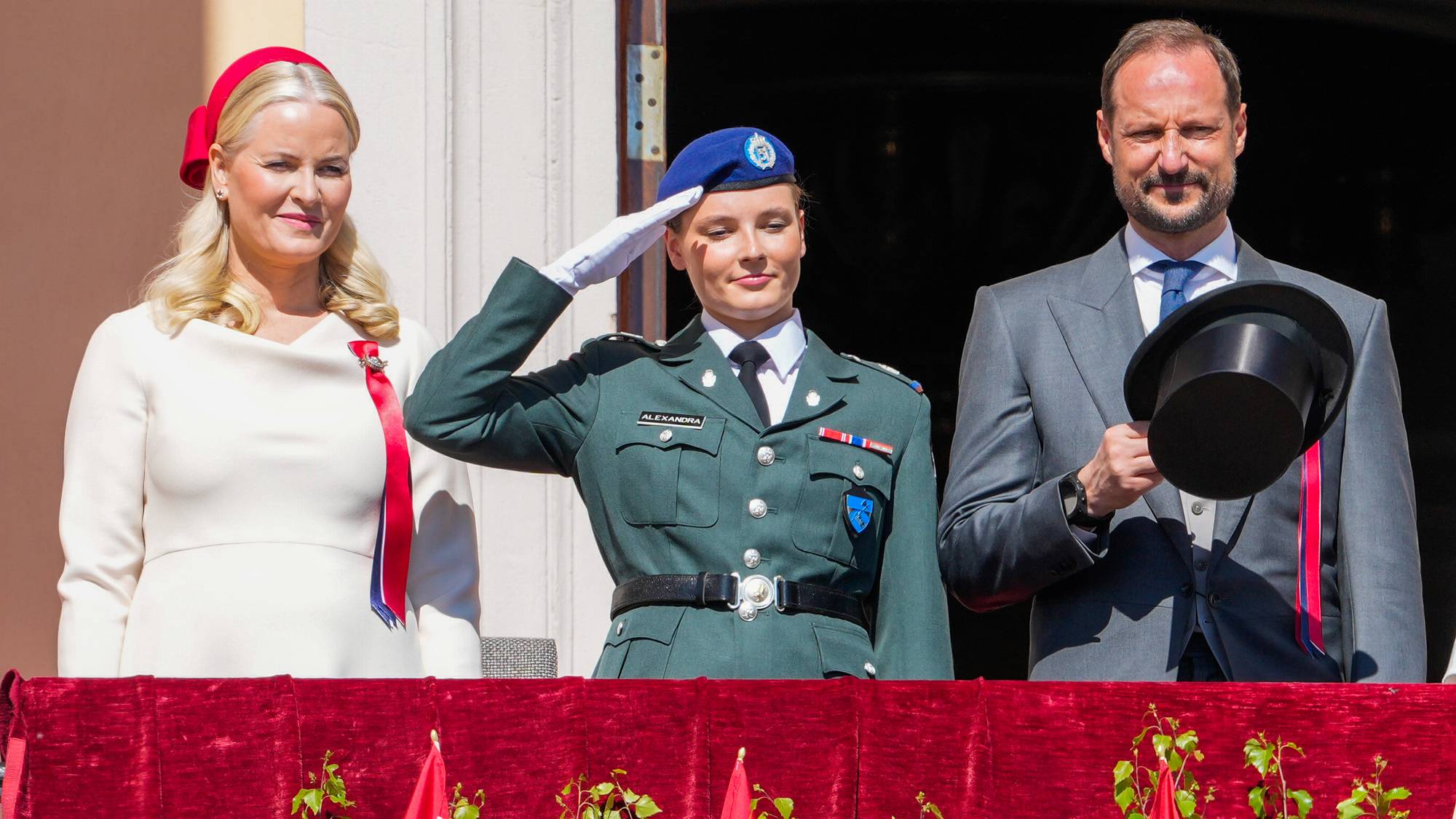 Kronprinsesse Mette-Marit, kronprins Haakon og prinsesse Ingrid Alexandra iført Hærens tjenesteuniform hilser barnetoget i Oslo fra Slottsbalkongen på Slottet.