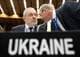 JOE KLAMAR / AFP / NTB To personer i dress står nært hverandre, mens de snakker. I bakgrunnen er det andre personer og en konferansesal. Et skilt med teksten "UKRAINE" er tydelig i forgrunnen. Omgivelsene indikerer en formell sammenkomst eller konferanse.