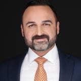 Foto: Nasseri Legal En mann i hvit skjorte og dress ser rett i kamera.