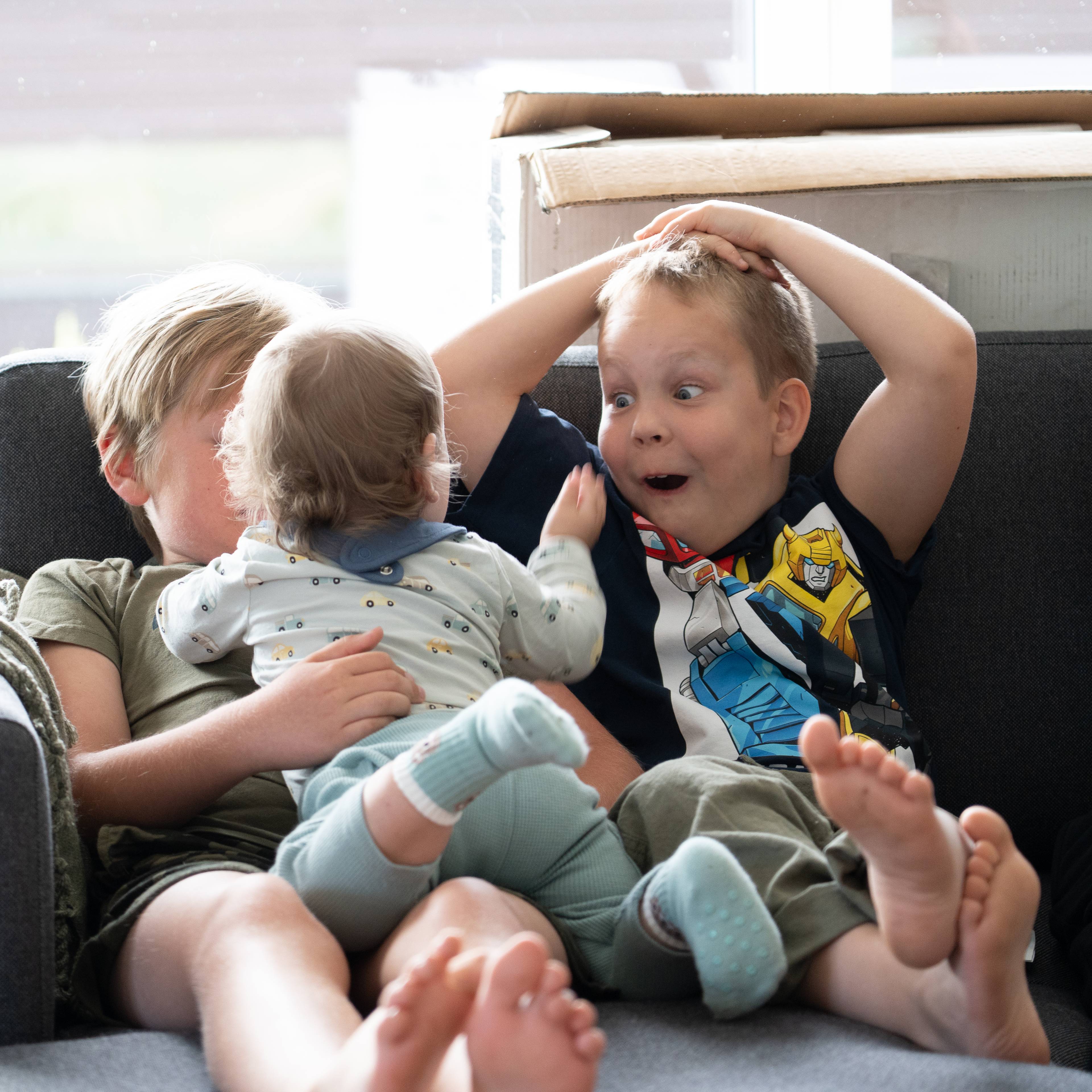 Barn leker i en sofa