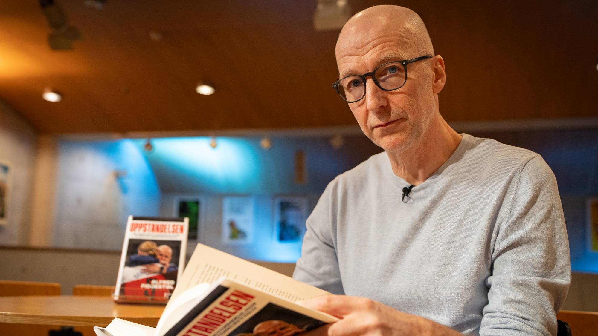 Alfred Fidjestøl holder boken "Oppstandelsen" i hendene