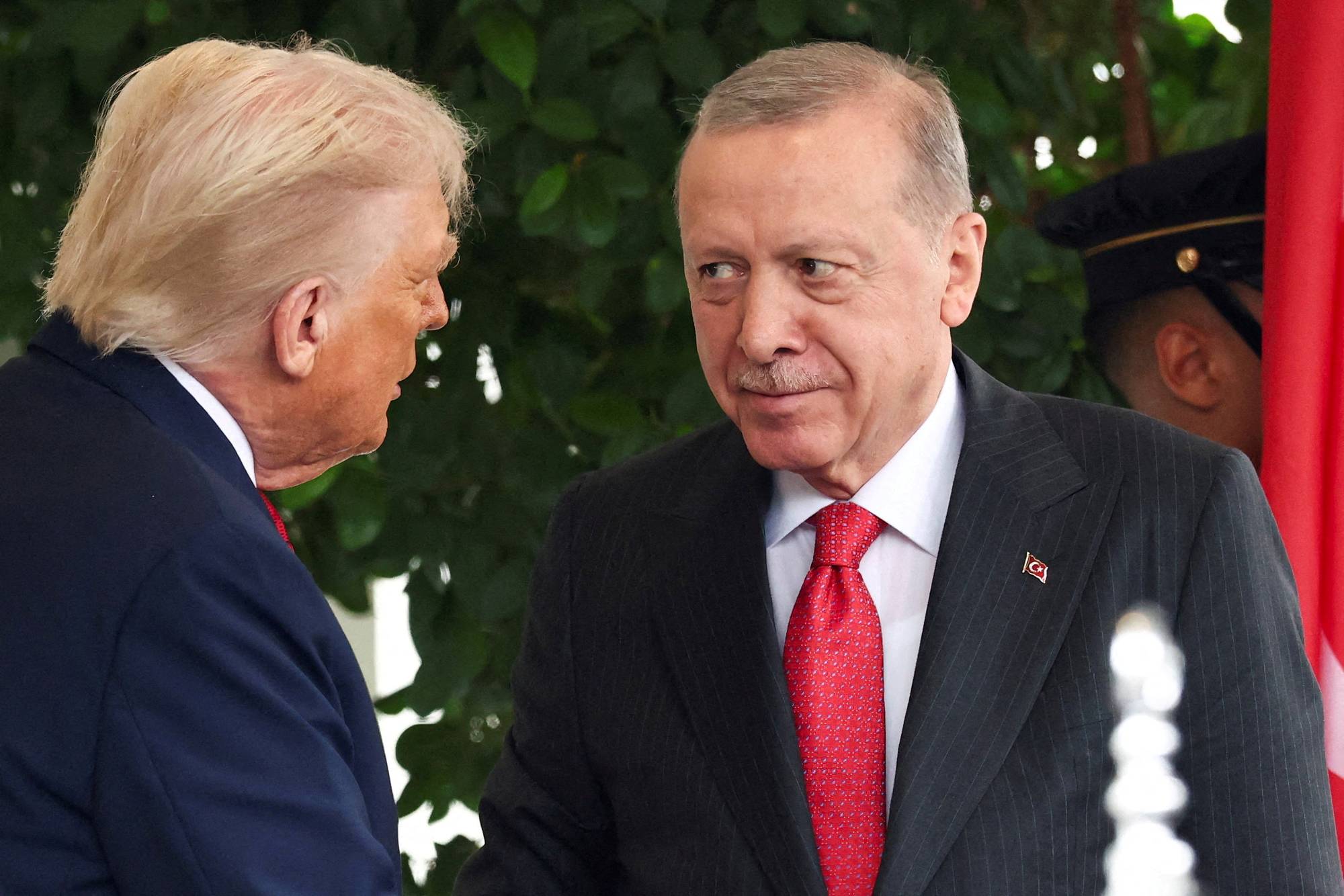 Recep Tayyip Erdogan i dress og slips som ser på Donald Trump