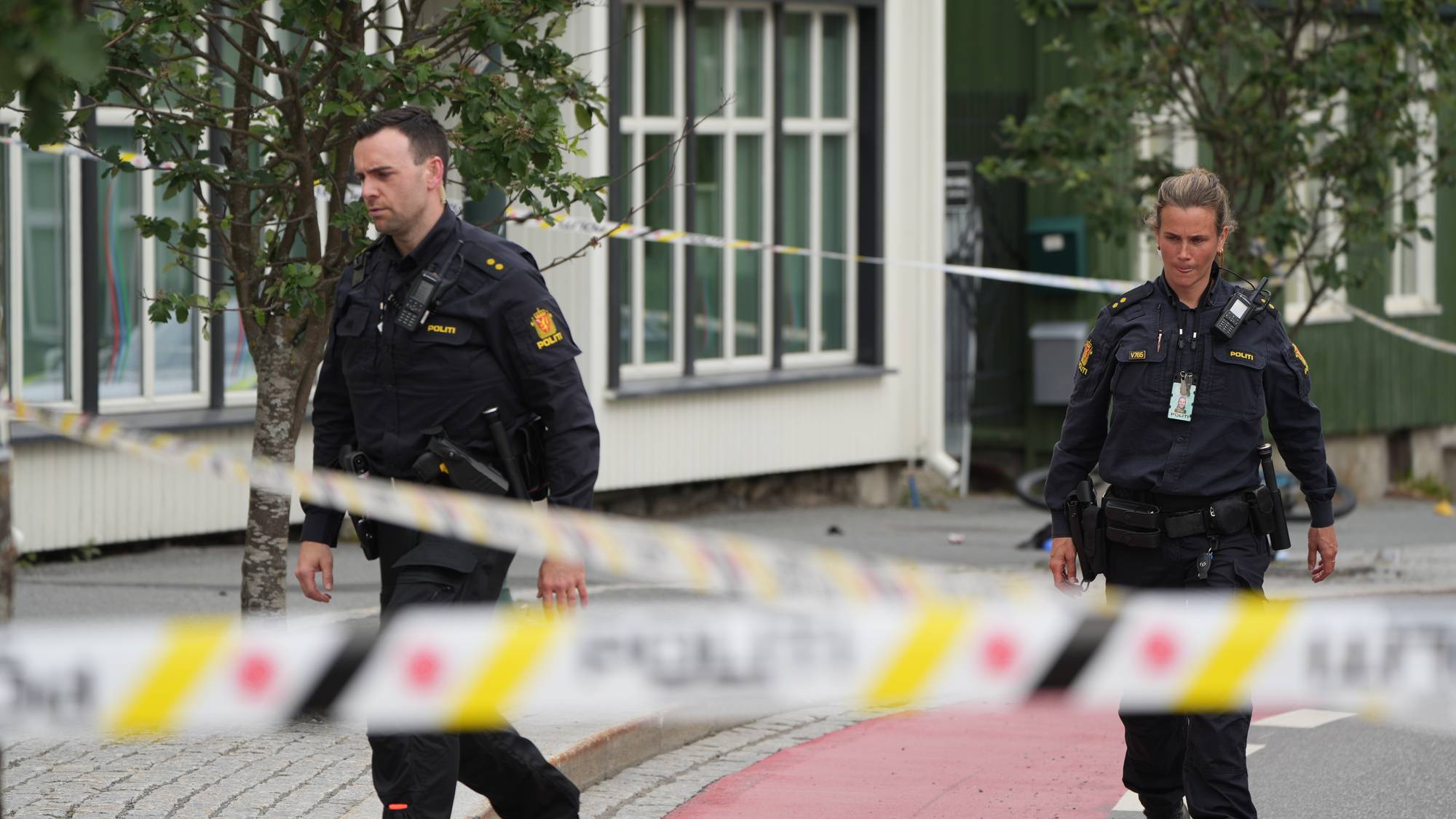 et par menn i uniform som går nedover en gate