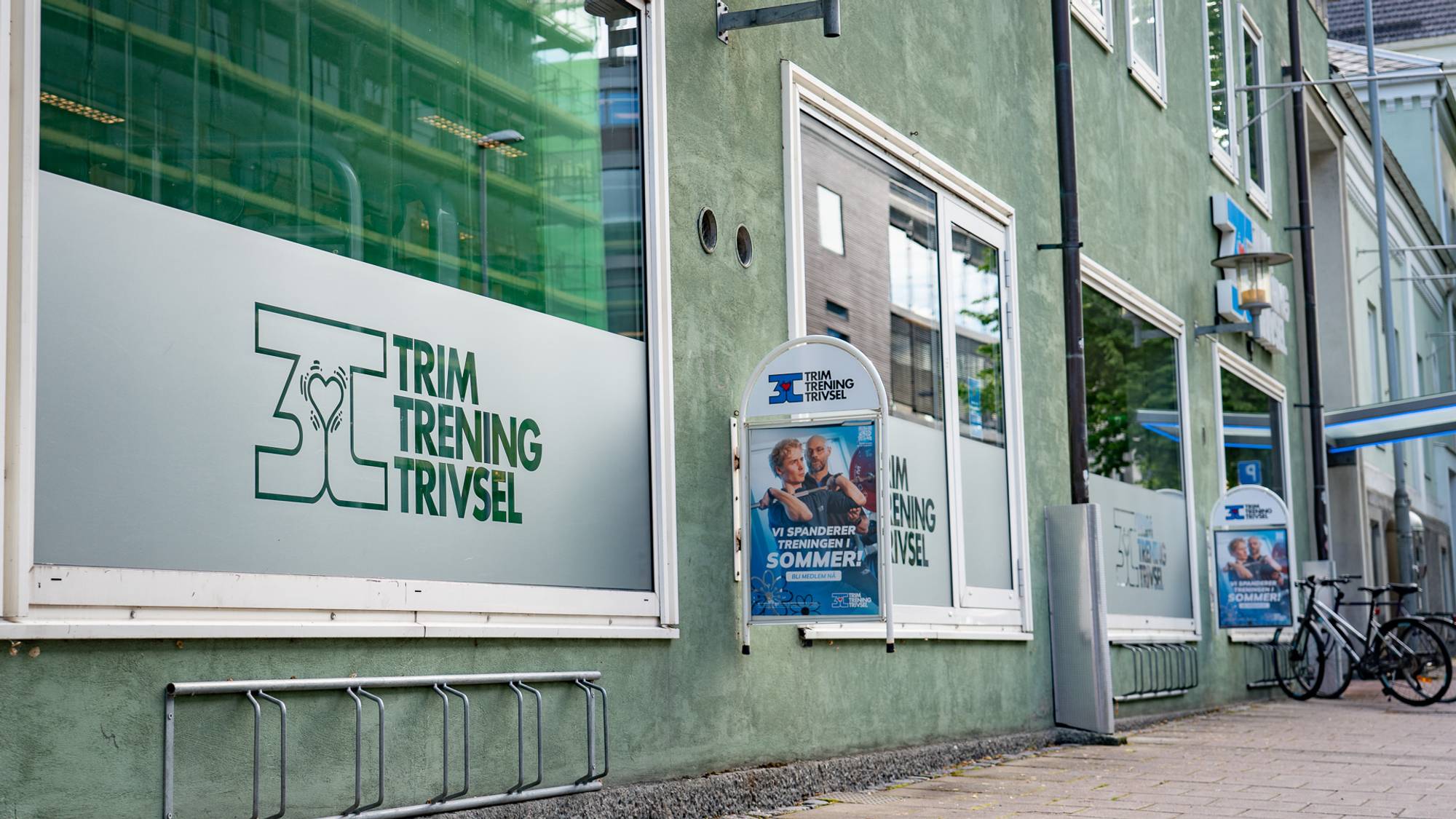 På utsiden av treningssenteret 3T Midtbyen i Trondheim sentrum. På Vinduene står det "3T Trim, trening, trivse"