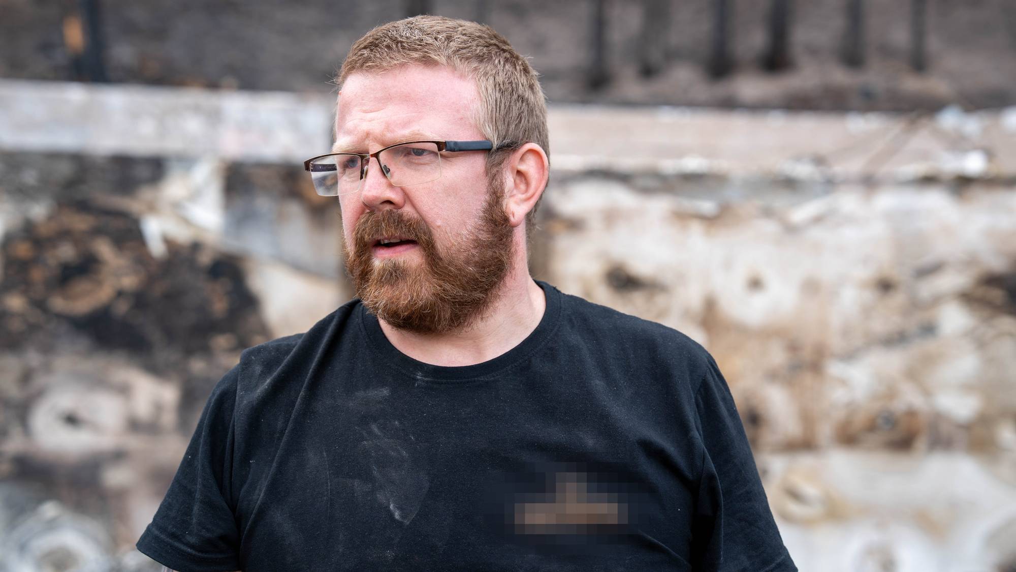 Håkon står i sitt nedbrente barndomshjem
