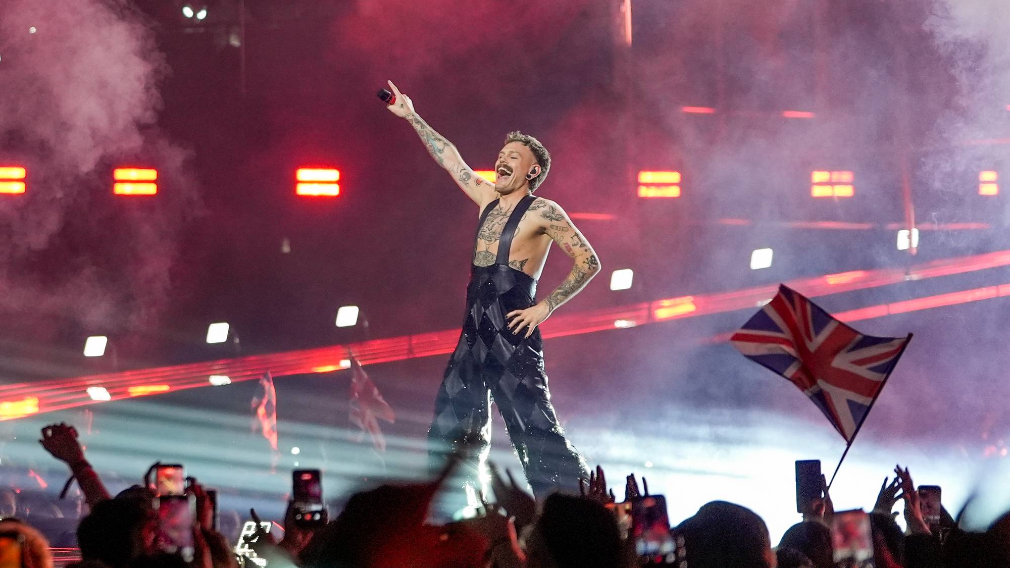 Jonas Lovv står på Eurovision-scenen ikledd hengselbukse og bar overkropp