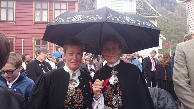 BUNADEN PÅ: Bjørghild Holien og Kristin Evensen i fin Valdres-bunad og med paraply under 17. mai-feiringa i Lærdal.