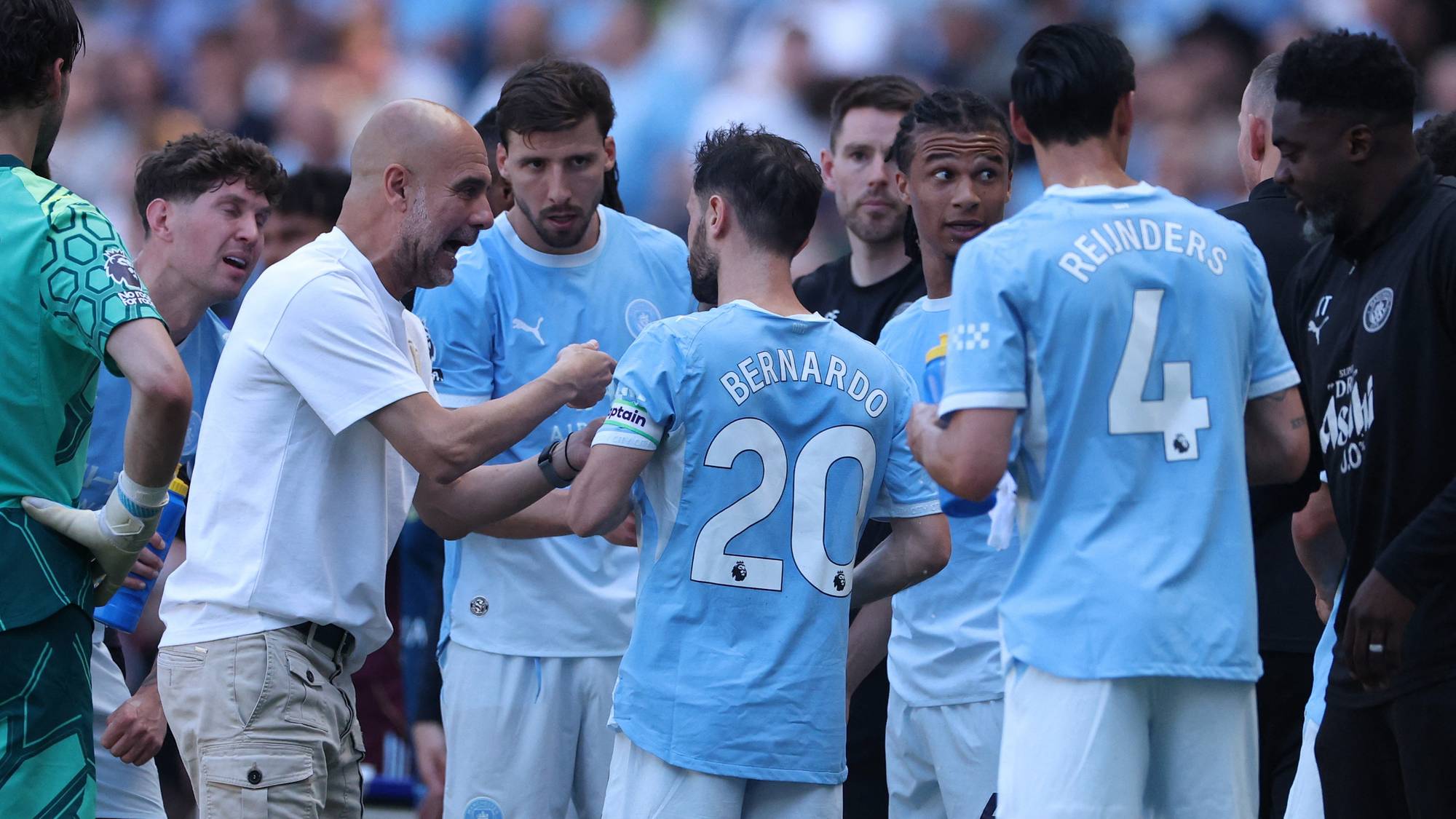 Manchester City-trener Pep Guardiola gir instrukser til spillere på banen under en fotballkamp. (Bildebeskrivelsen er laget av en KI-tjeneste)