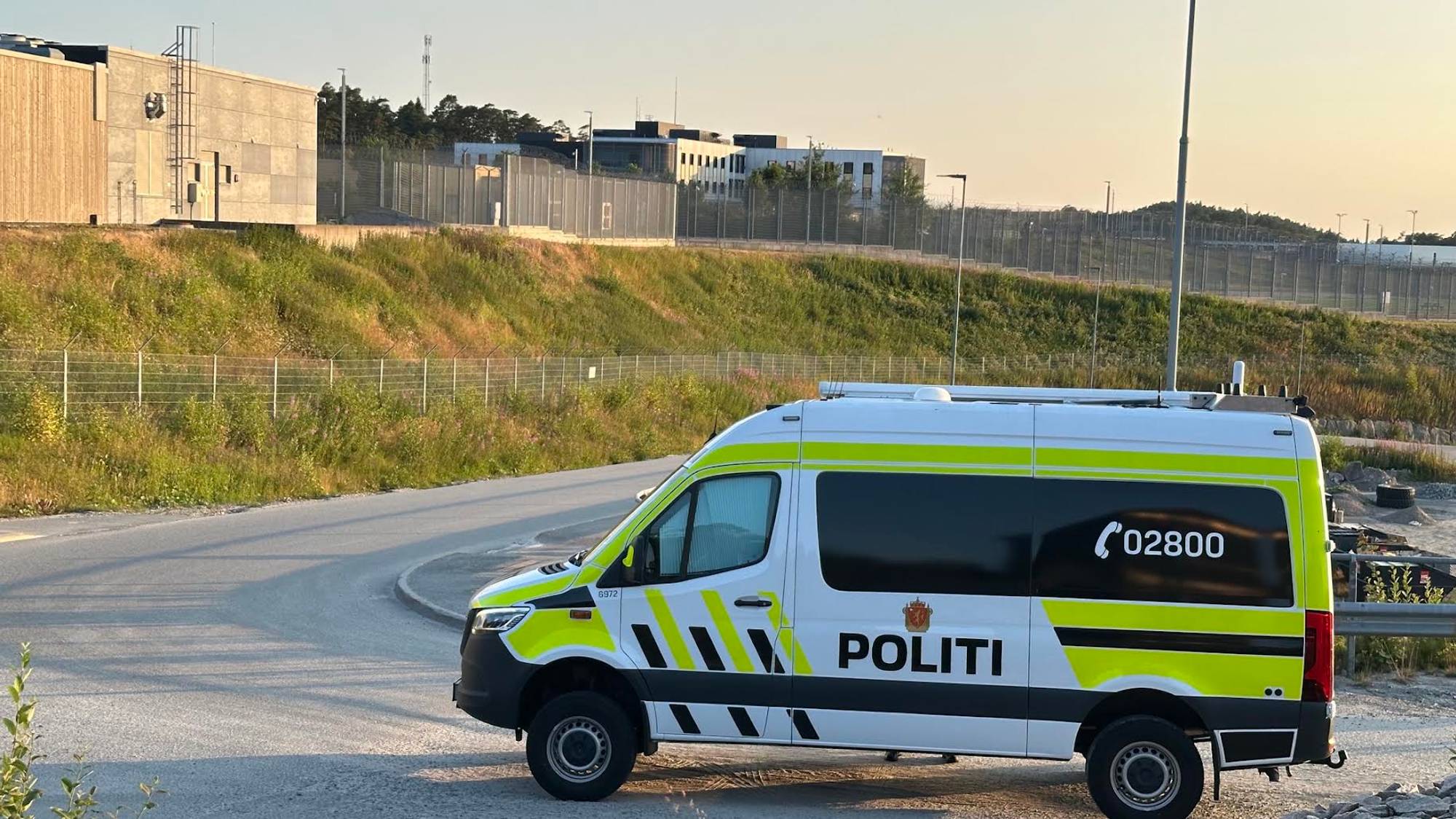 En politibil står parkert foran et fengsel.