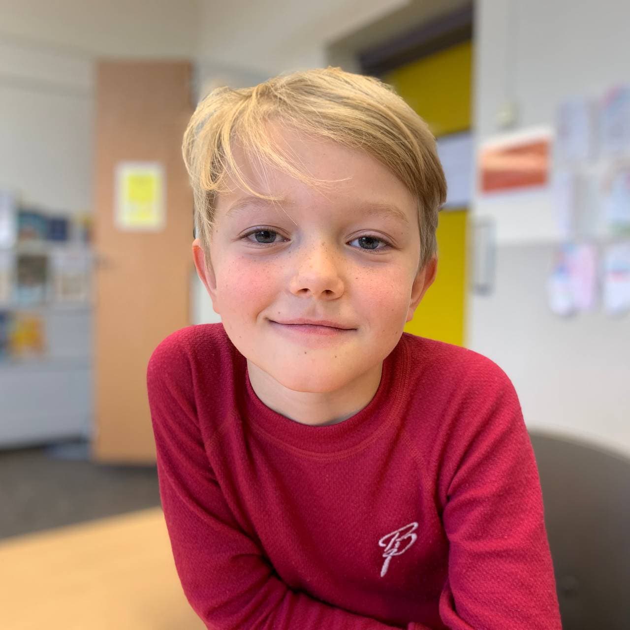 Magnus sitter ved pulten i klasserommet.
