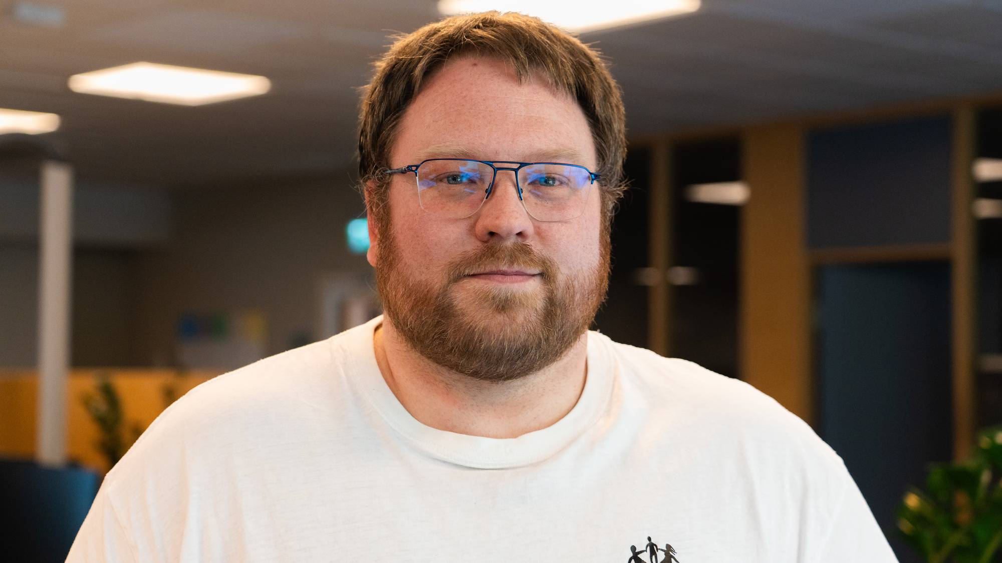 viser en mann med skjegg og briller som ser i kamera