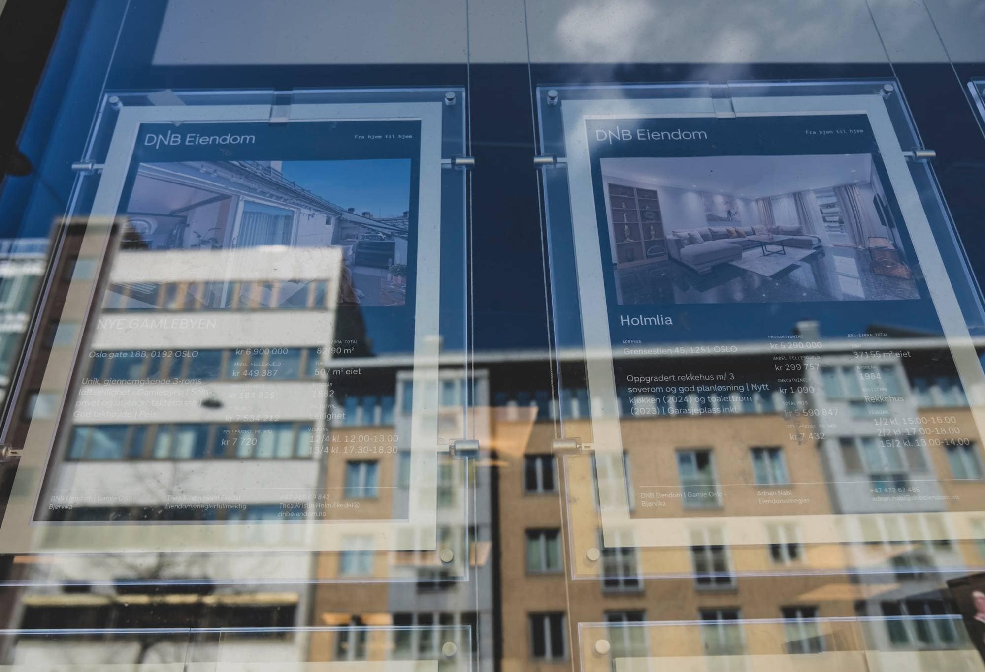 Bilde av vindu med boligannonser, Oslo fasader reflekteres i vinduet