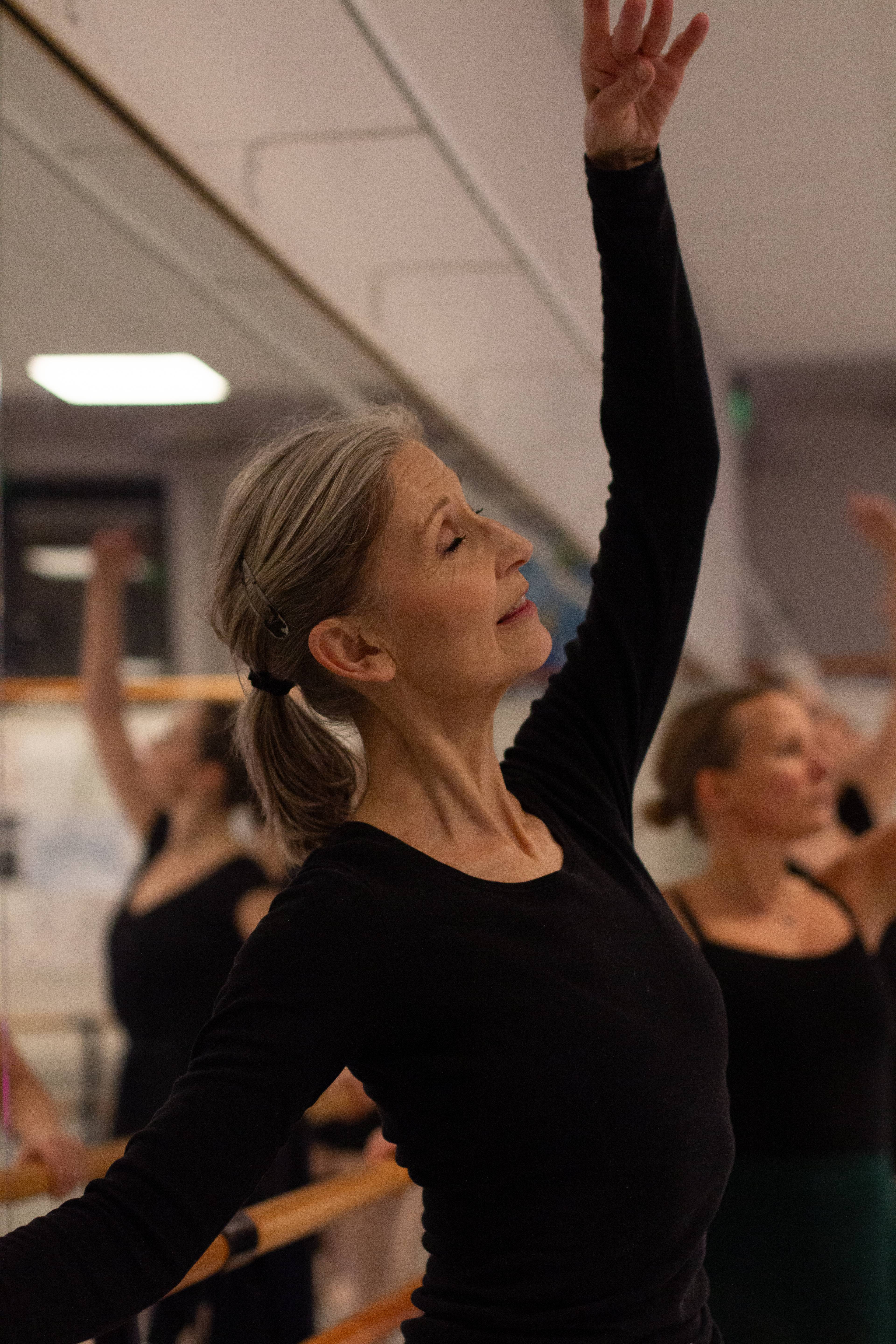 en kvinne med grått hår danser ballett