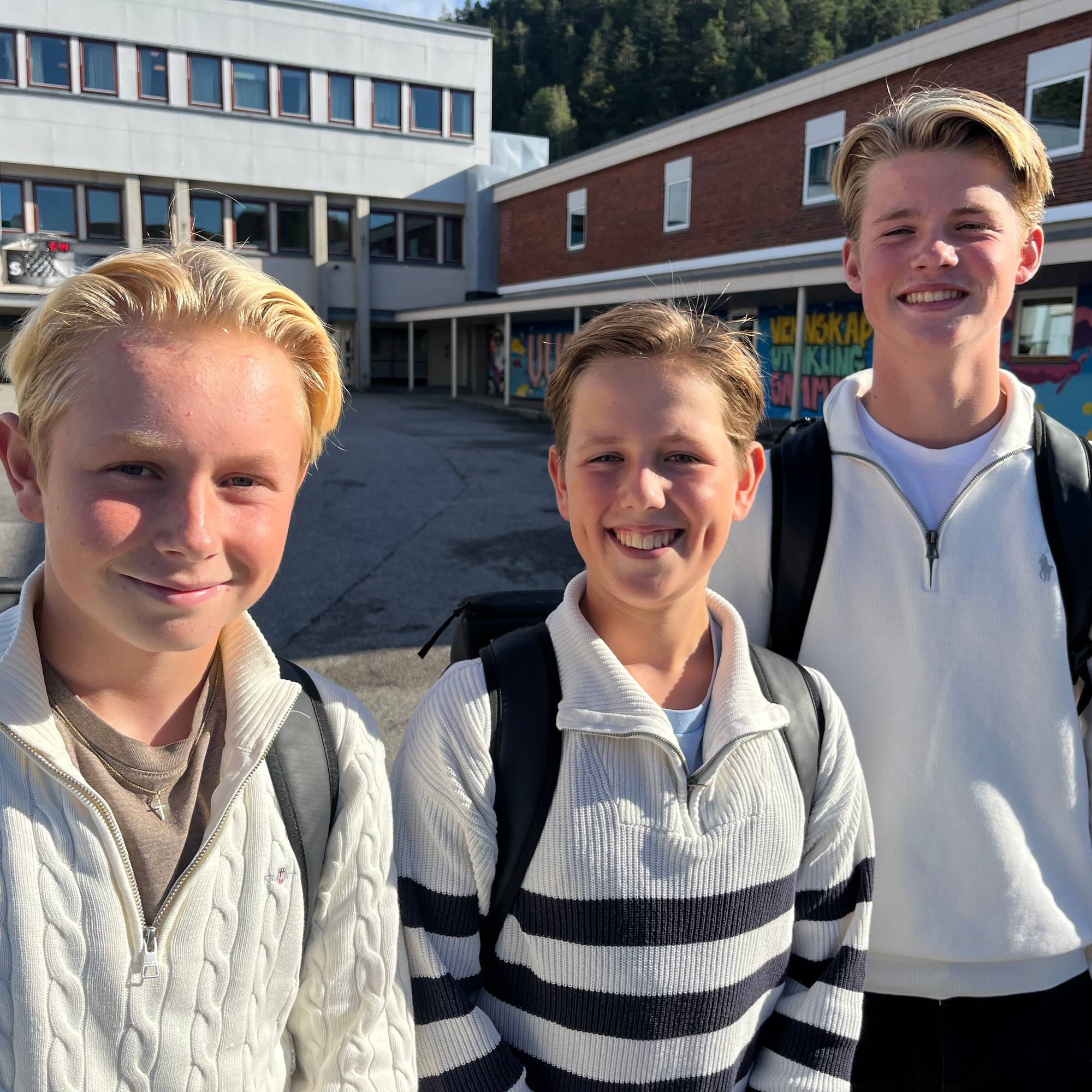 Tre unge gutter på en skolegård