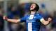 Christoffer Andersen / NTB Fotballspiller med svart hodebeskyttelse jubler med armene løftet og knyttnever. Han har blå og hvit drakt med sponsorlogoer. I bakgrunnen sees utydelige publikummere. (Bildebeskrivelsen er laget av en KI-tjeneste)