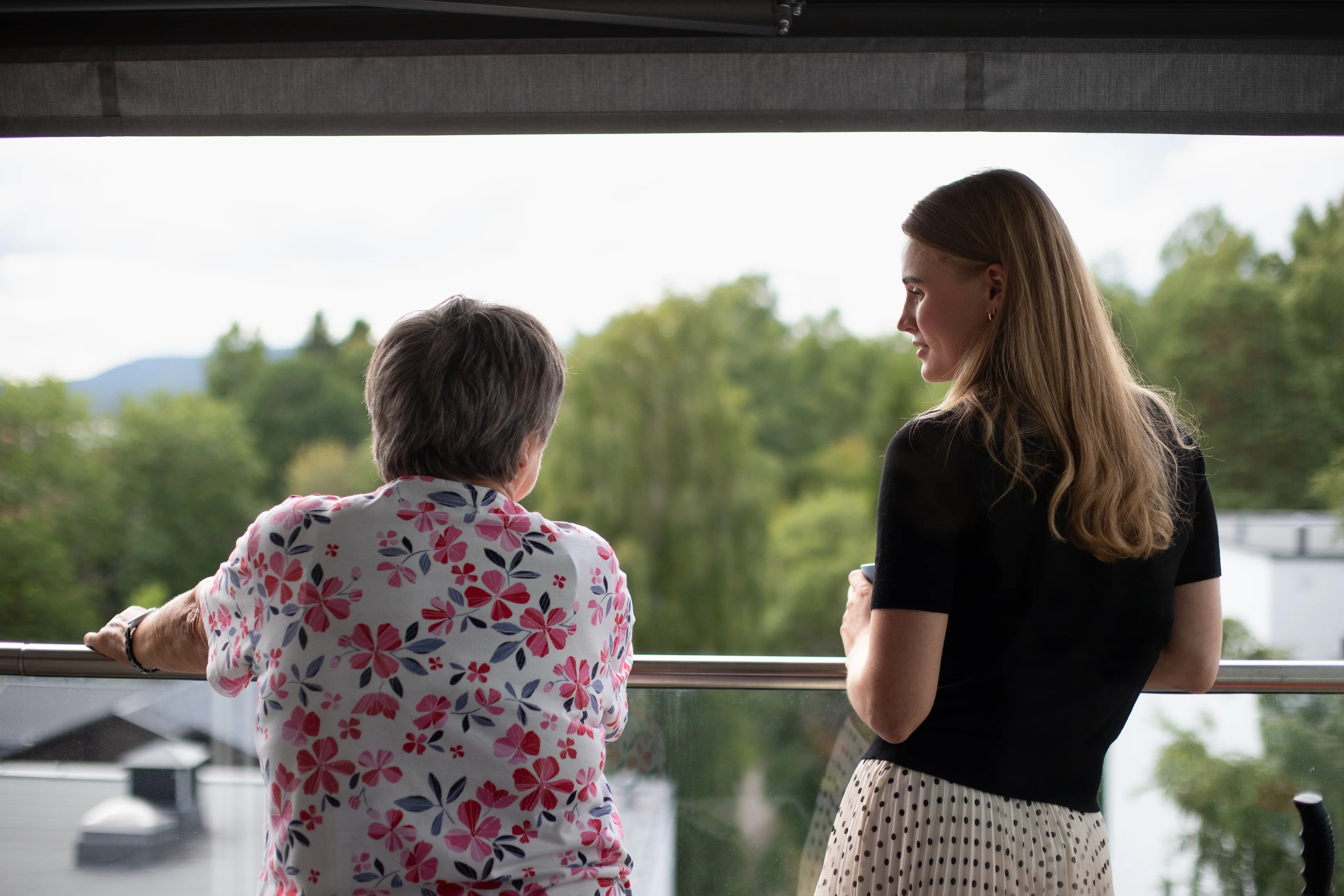 en eldre kvinne og en ung kvinne som står på en balkong