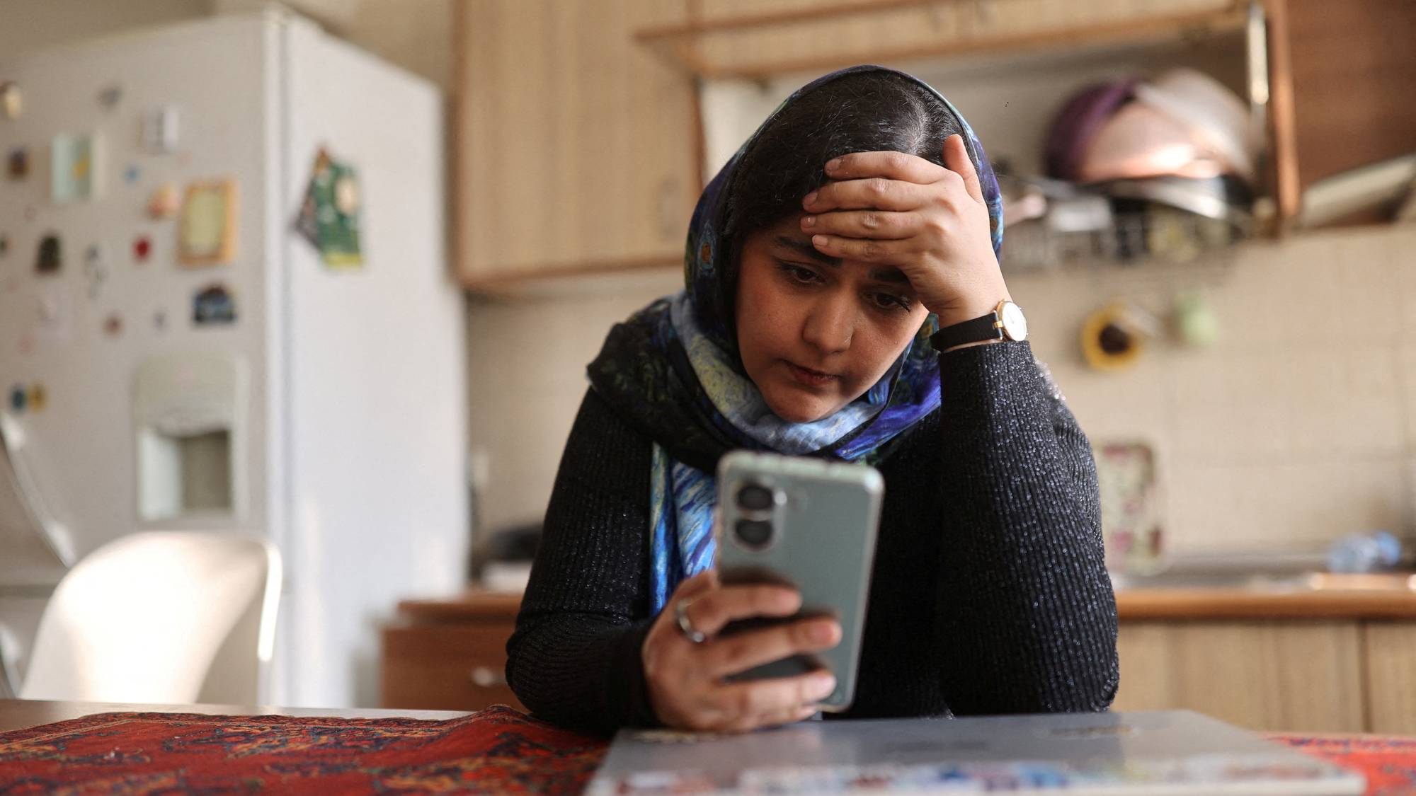 Kvinne i Iran ser på mobilen sin 