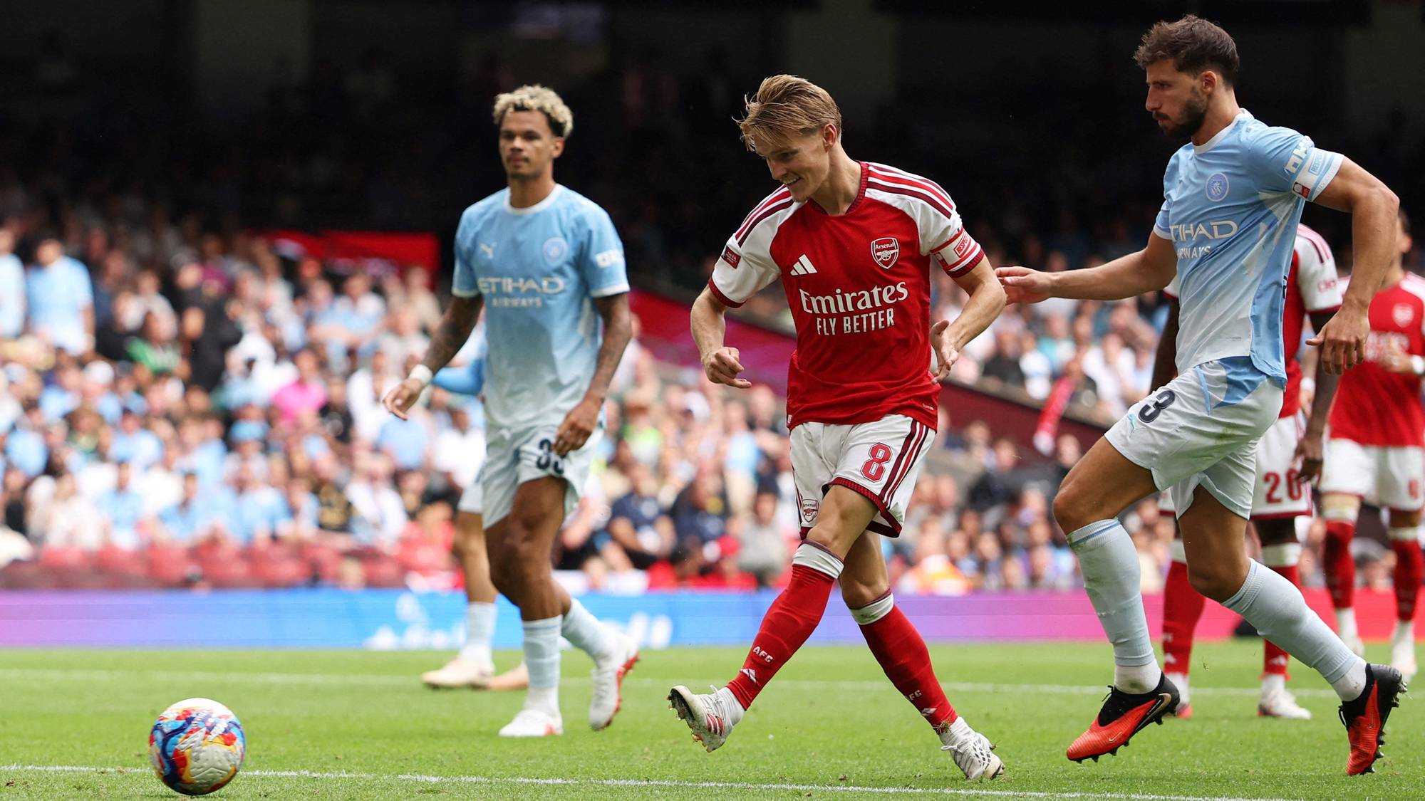 Martin Ødegaard for Arsenal skyter ballen i kamp mot Manchester City. (Bildebeskrivelsen er laget av en KI-tjeneste)
