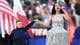 Foto: Lisi Niesner / REUTERS,NTB Sangeren Katy Perry synger under et arrangement. Ved siden av henne står en gutt som holder en mikrofon. De holder hender. Bak dem er det flagg og et publikum. (Bildebeskrivelsen er laget av en KI-tjeneste)