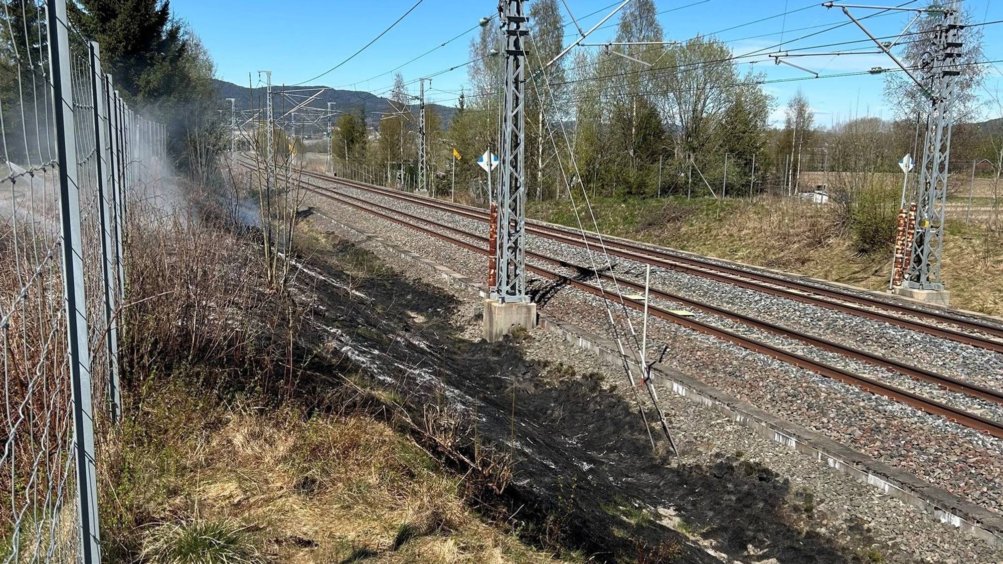 Svidd gress rett ved siden av jernbanesporet