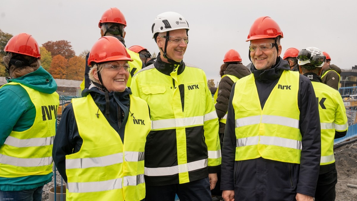 Tre personer i gul vest og med hjelm står på en byggeplass FOTO: Andreas Sundby/NRK