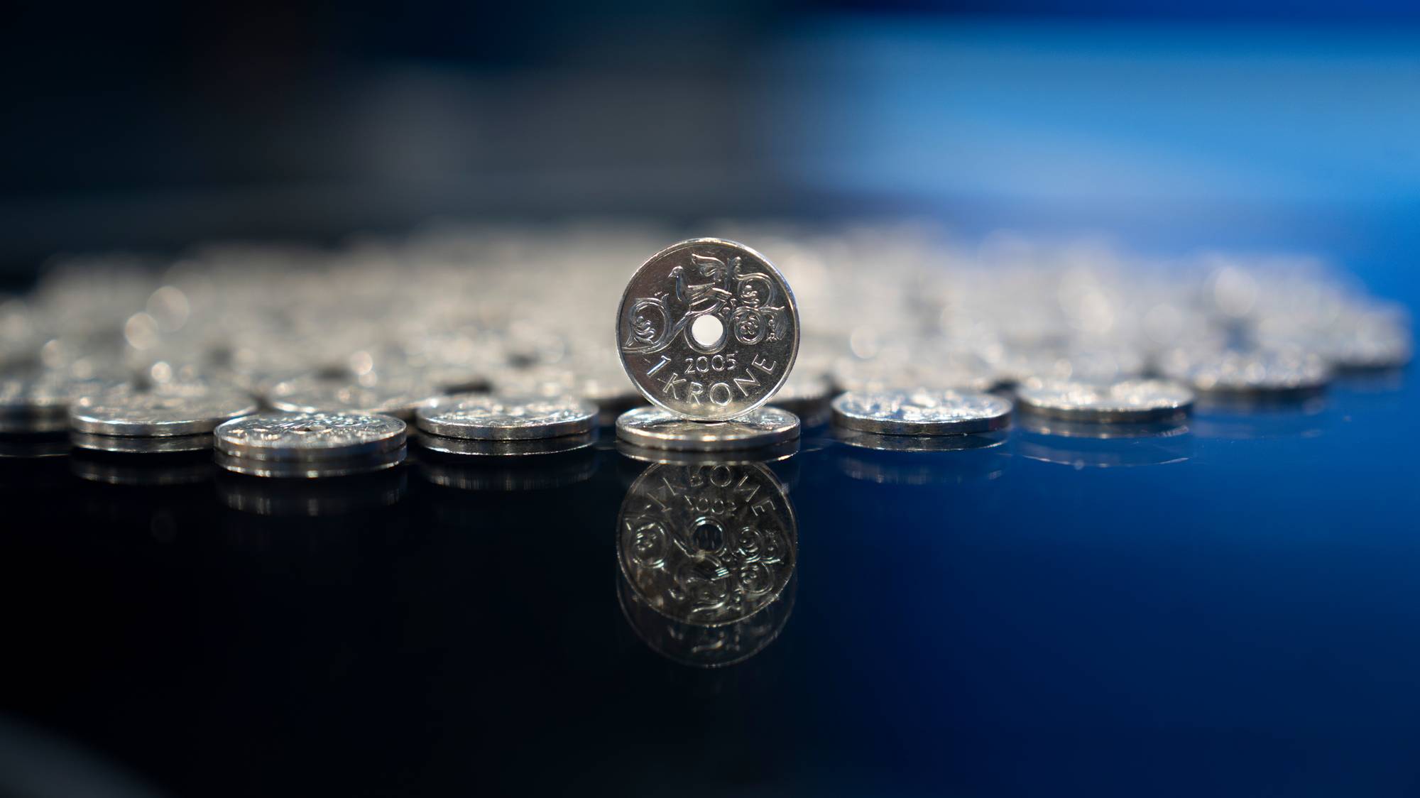 En enkroning står oppå en haug med enkroninger. 