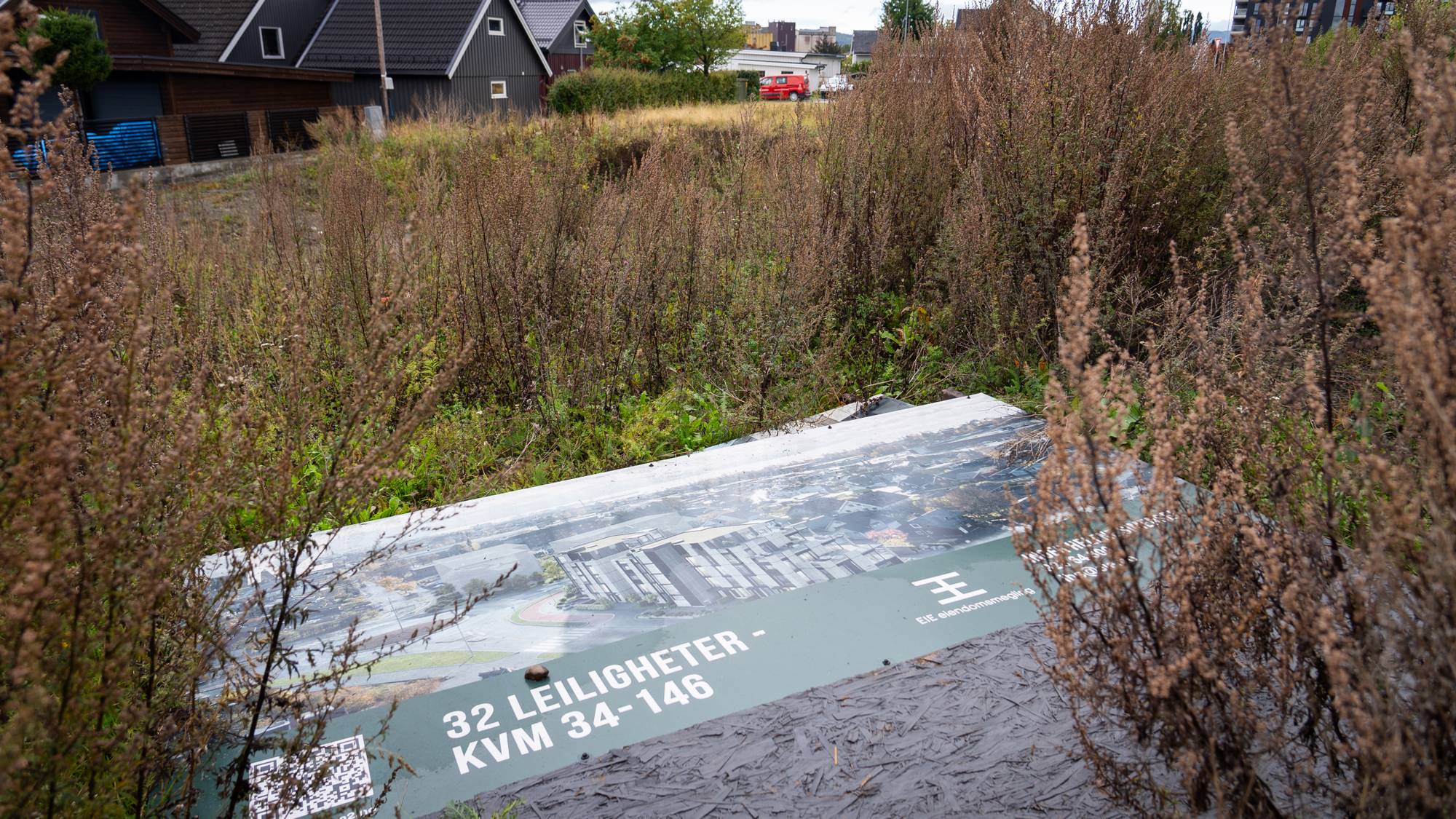 En boligplakat som beskriver de planlagte leilighetene som var planlagt her ligger på bakken