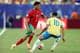 CHARLY TRIBALLEAU / AFP,NTB Fotballspiller fra Marokko i duell med en motspiller fra Brasil på en gressbane.