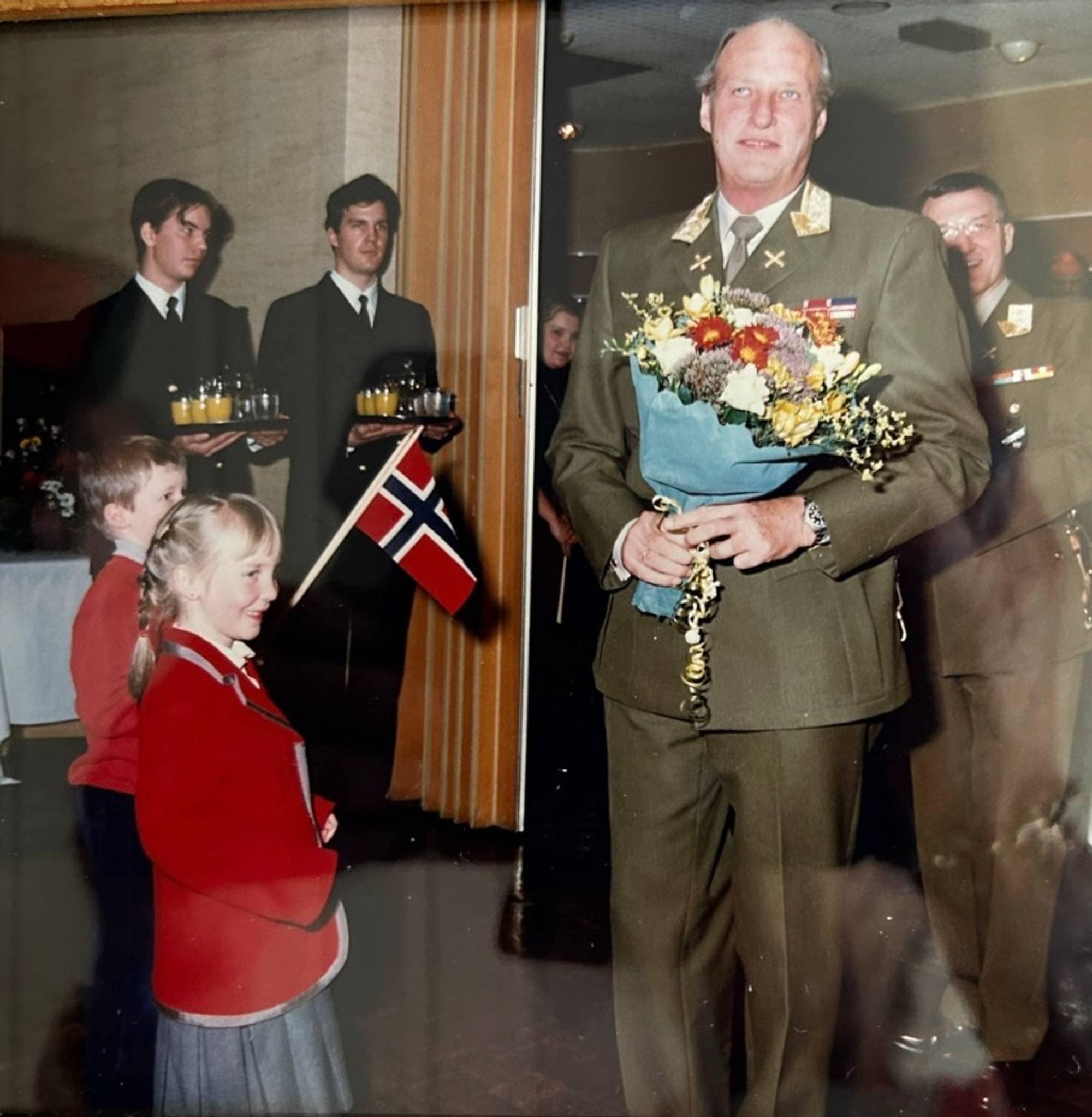 Bilde av to små barn med Kong Harald.